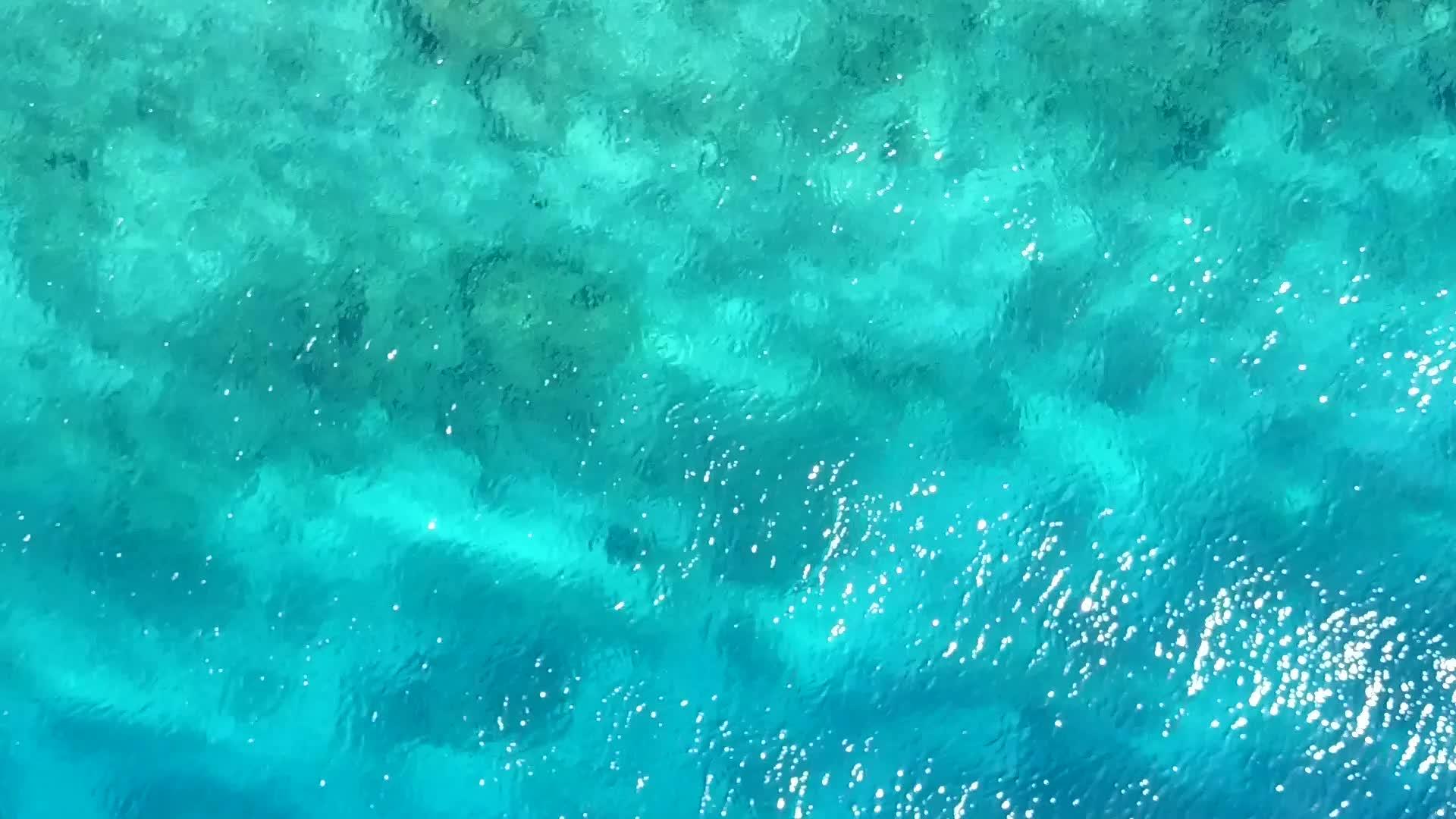 蓝水和白色沙滩背景的海平面航行视频的预览图