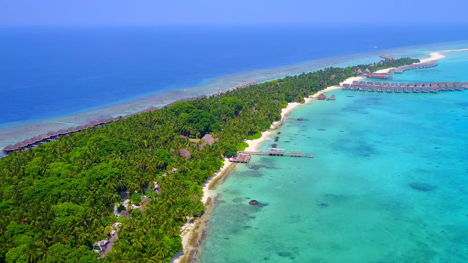 在蓝色海洋和干净的沙质背景下放松在海滩上航行的无人机视频的预览图
