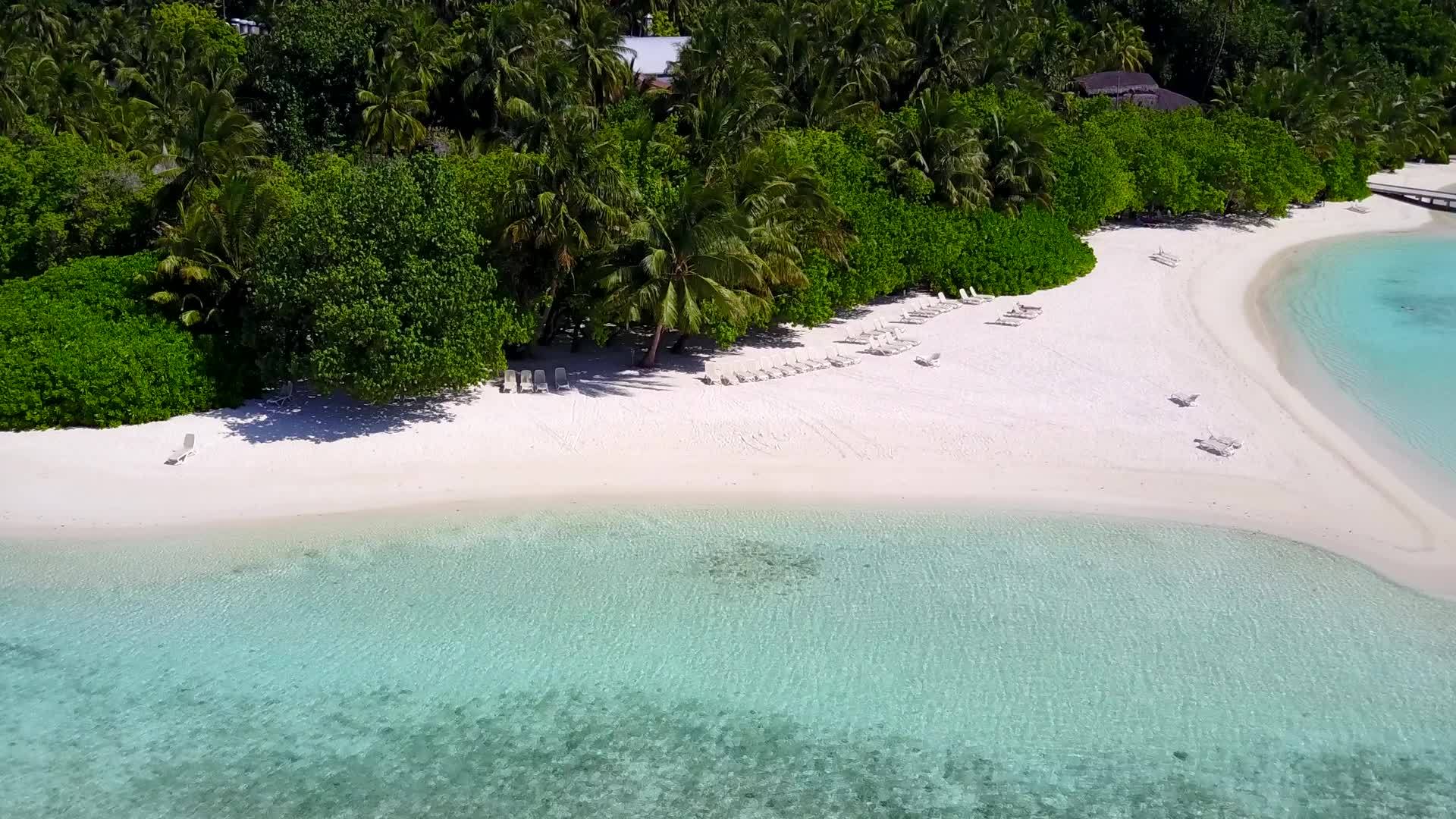 在蓝色、绿色的水和白色的沙子的背景下有一个安静的海岸线海滩视频的预览图
