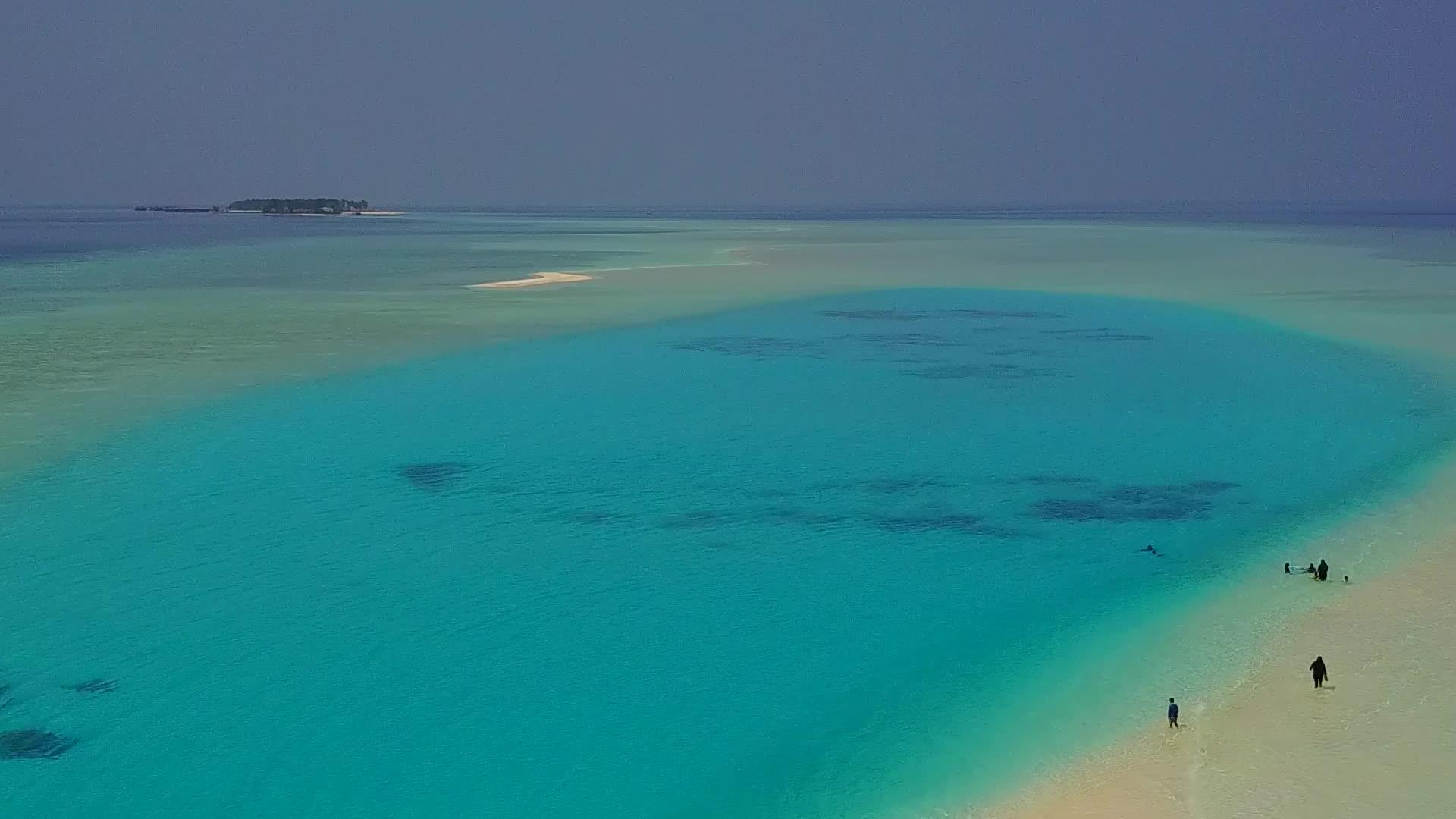 在浅环礁湖和白色沙滩的背景下在美丽的岛屿海滩上空行视频的预览图