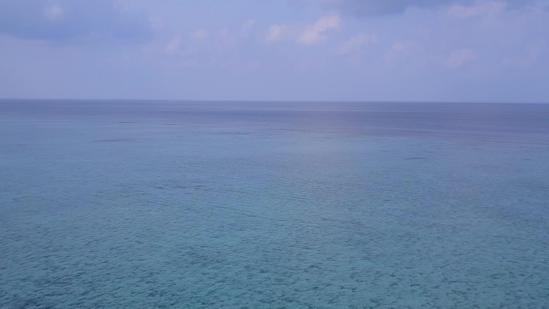 无人驾驶飞机以蓝绿色海洋和白色沙底的背景打破了海岸海滩视频的预览图