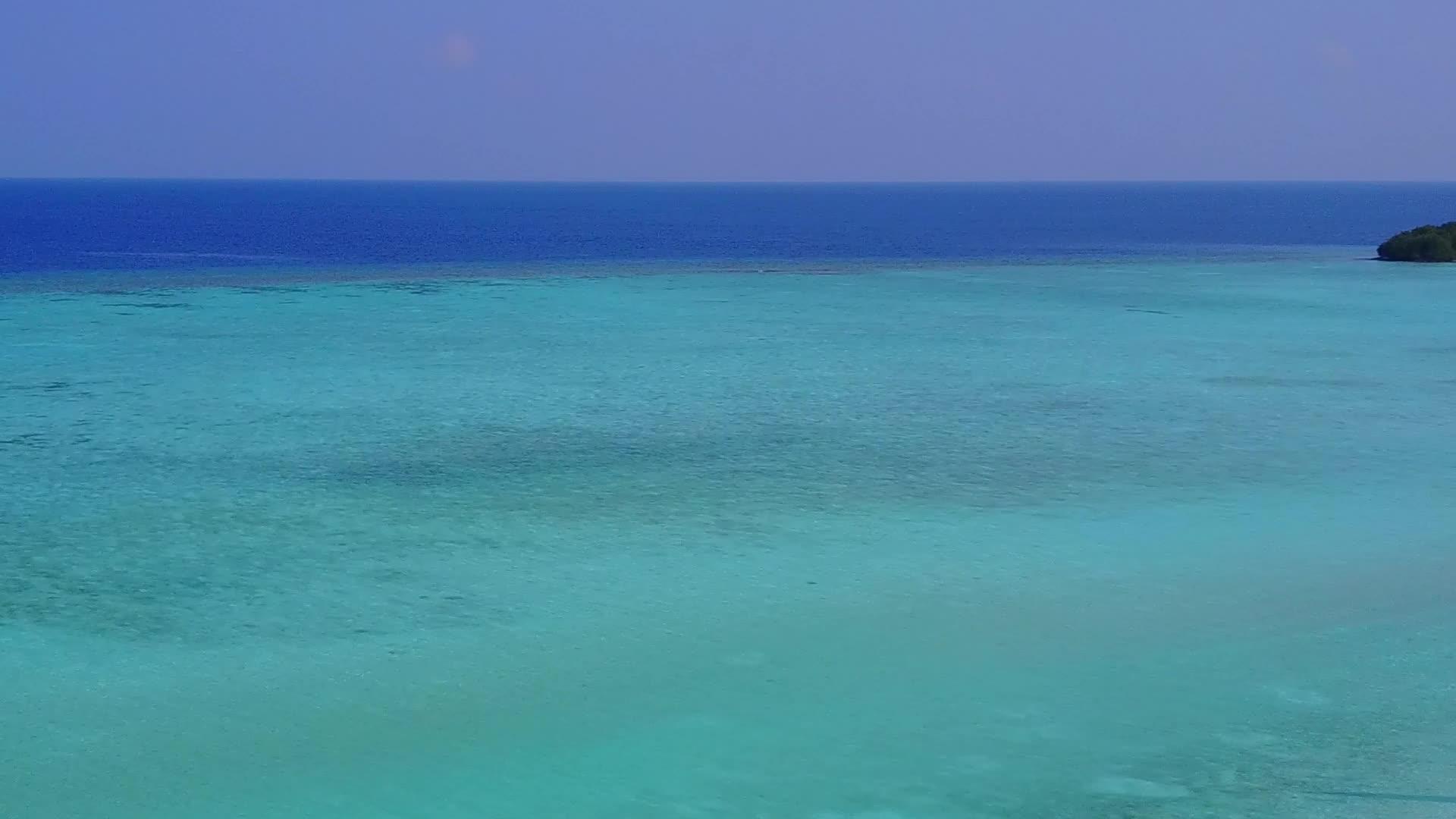 在蓝色泻湖和白沙的背景下无人机在宁静的度假胜地海滩上航行视频的预览图