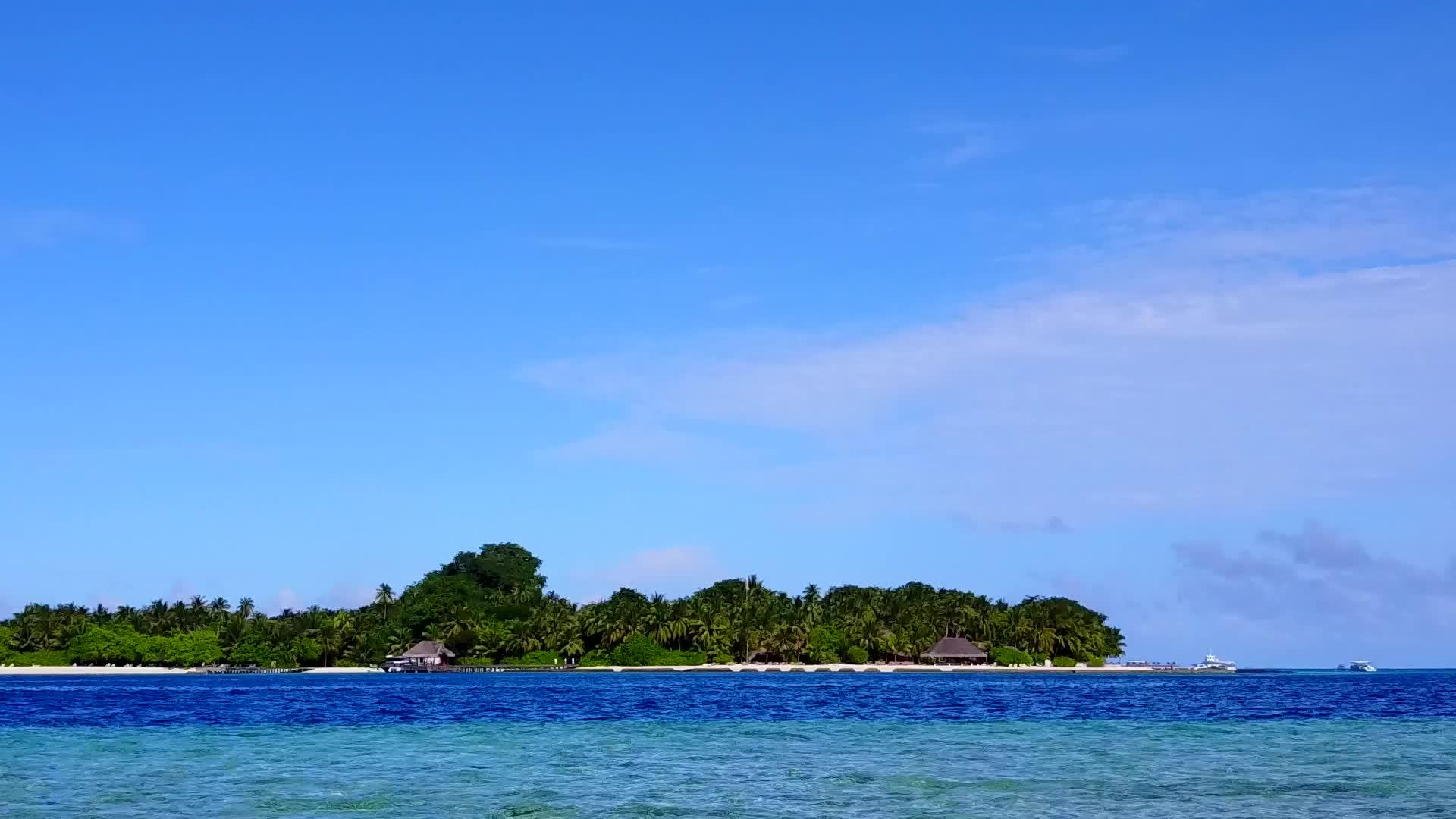 在透明的海面和白色的海滩背景下观察美丽的环礁湖海滩冒险视频的预览图