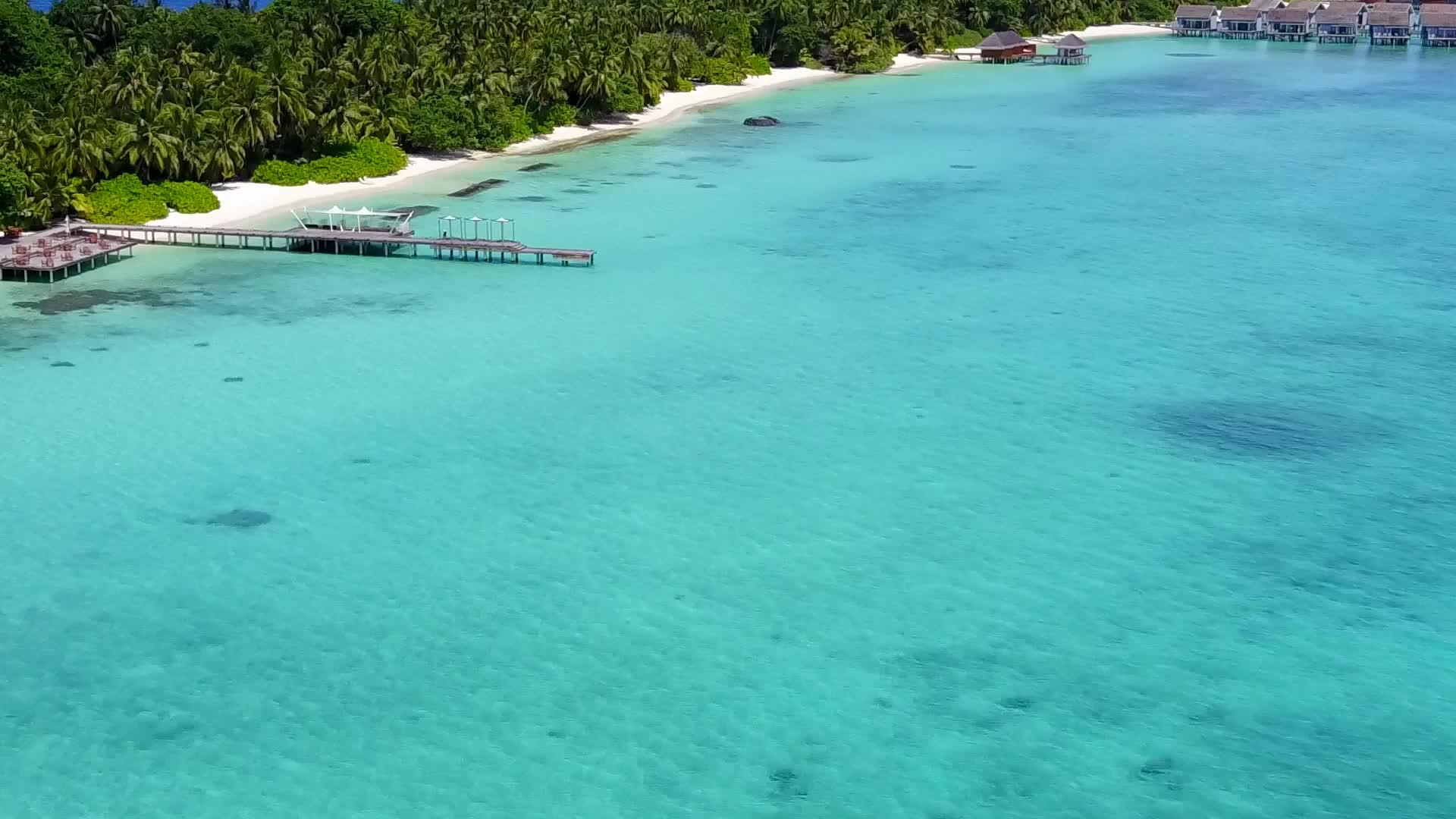 热带海滩在透明海水和白沙的背景下视频的预览图