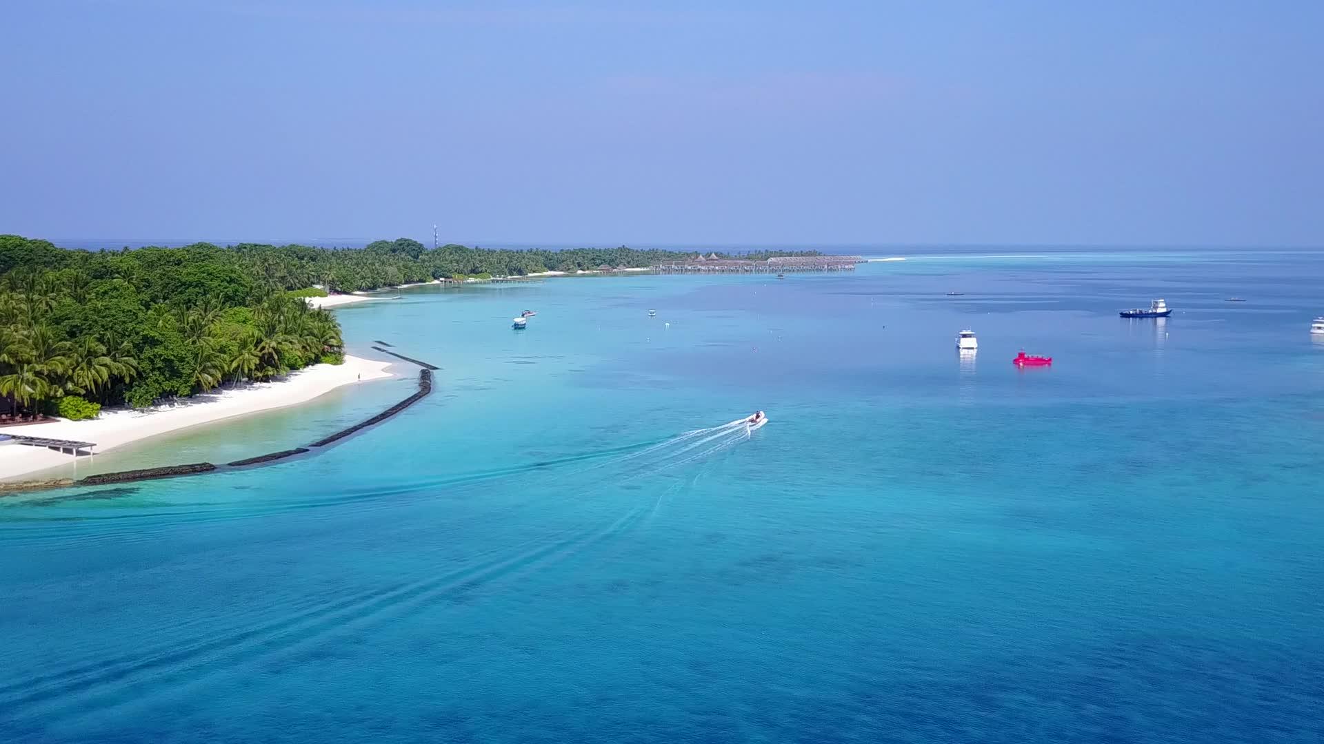 在蓝绿海和白沙的背景下在平静的环礁湖海滩上航行视频的预览图