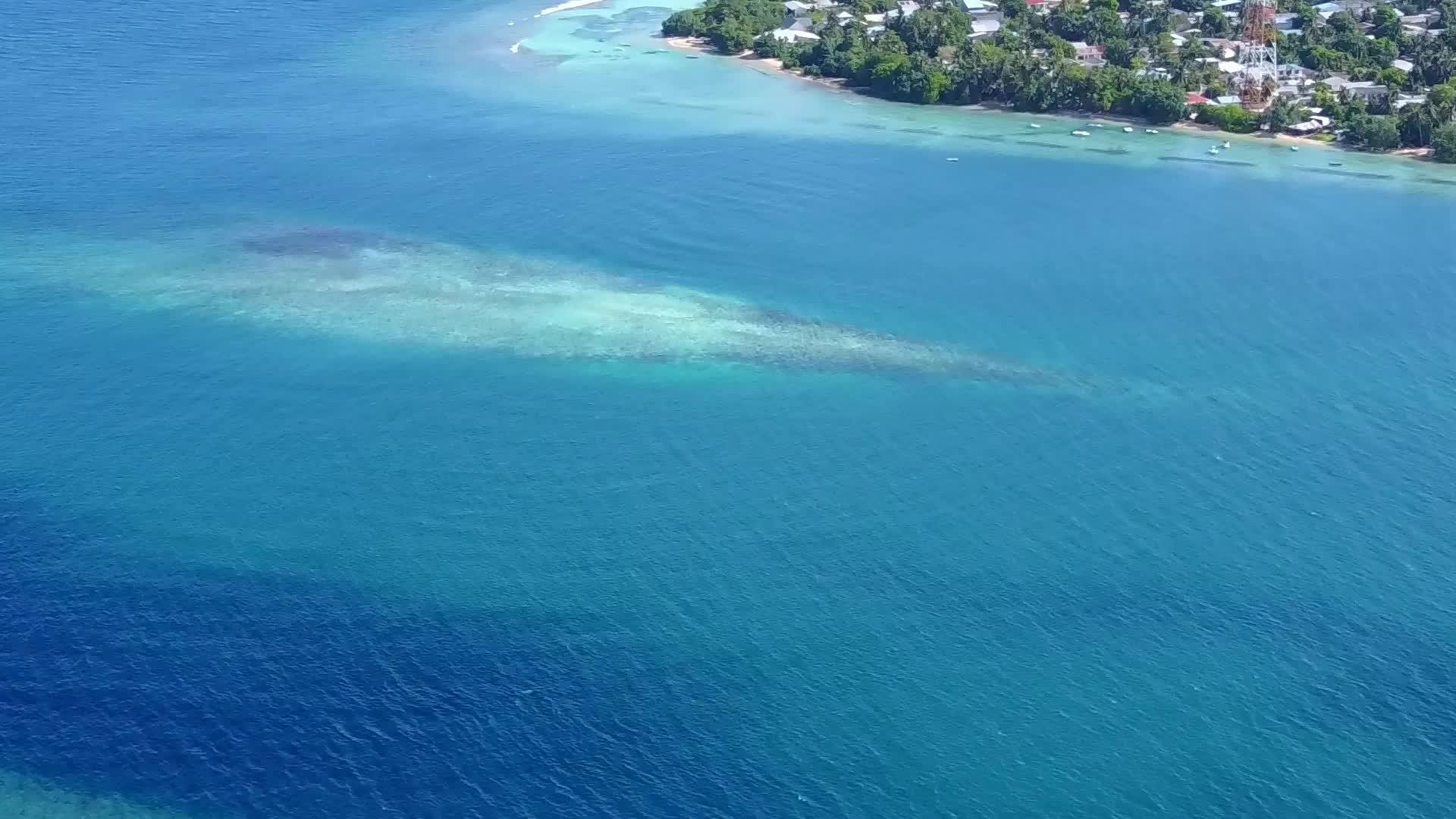空中无人驾驶飞机在蓝色的海平面上以清沙的背景放松海湾海滩视频的预览图