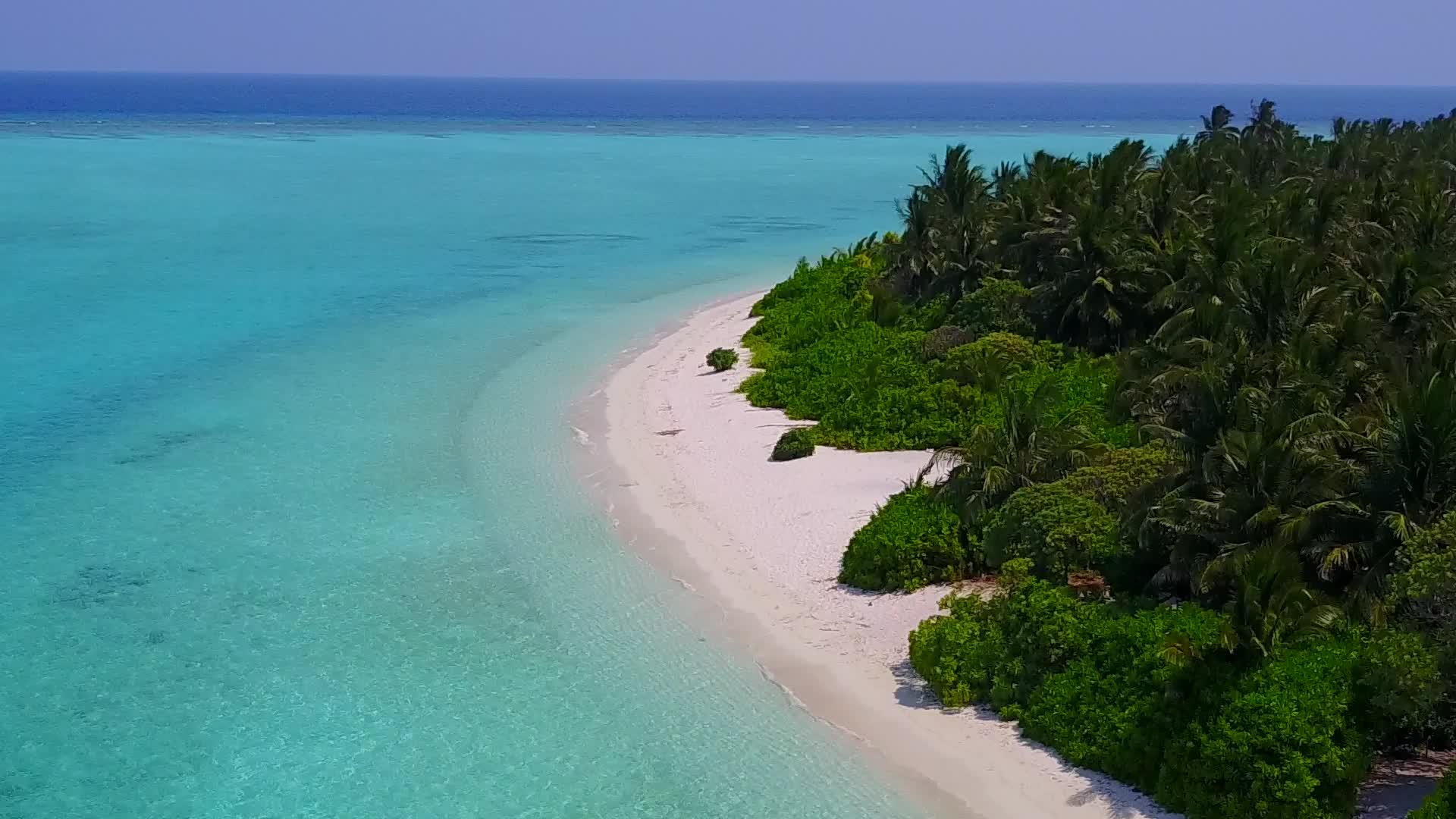 浅沙背景蓝绿色海洋田园诗般的海滩时间无人机视频的预览图