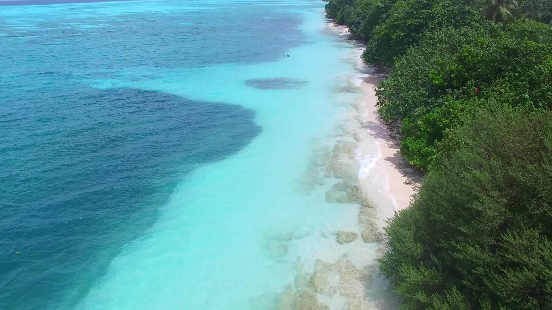 通过蓝色绿色海洋的蓝色绿色海洋在蓝色绿色海洋的白色沙面上欣赏伊德利岛的海滩视频的预览图