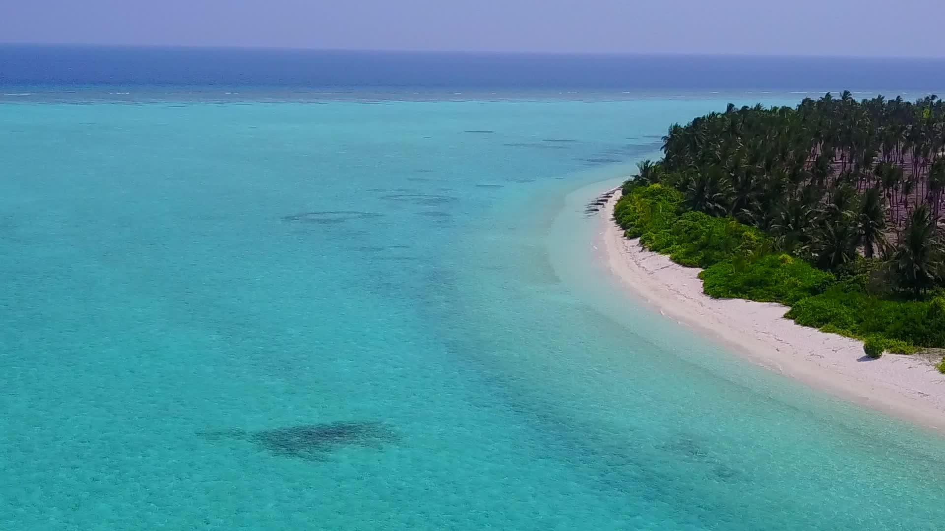 白色沙底蓝色环礁湖绘制的豪华海岸线野生生物空中结构图案视频的预览图