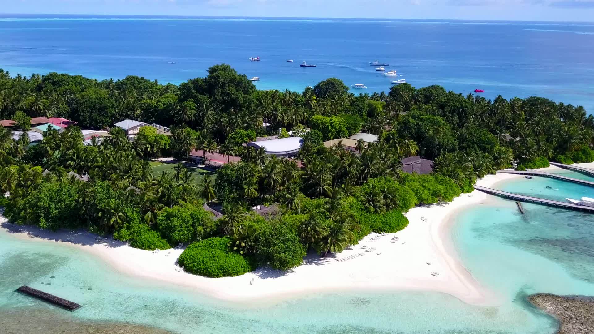 白色海滩背景下的绿水在美丽的海岸海滩度假胜地飞行视频的预览图