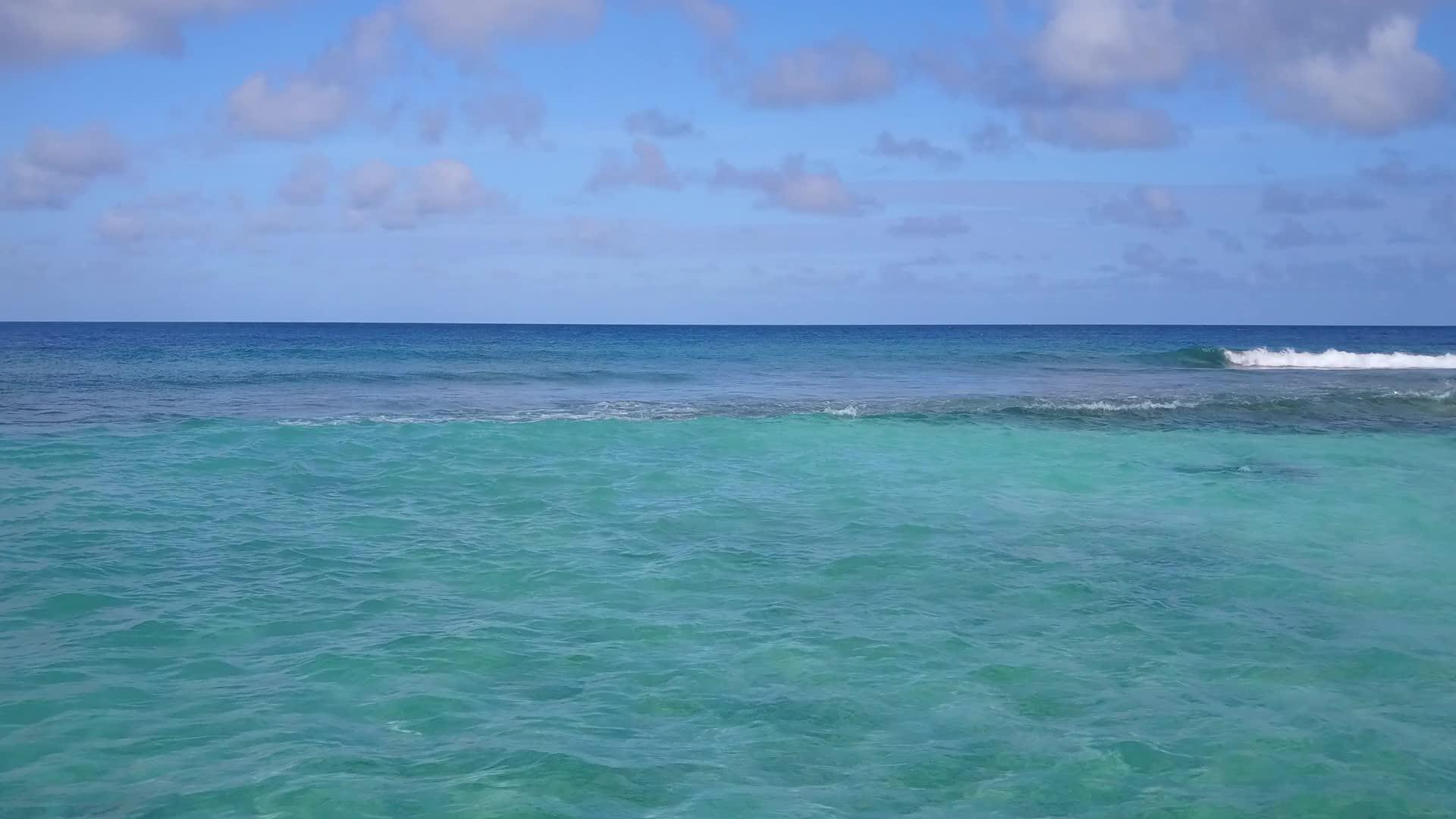 在蓝海和浅沙的背景下观赏宁静的环礁湖视频的预览图
