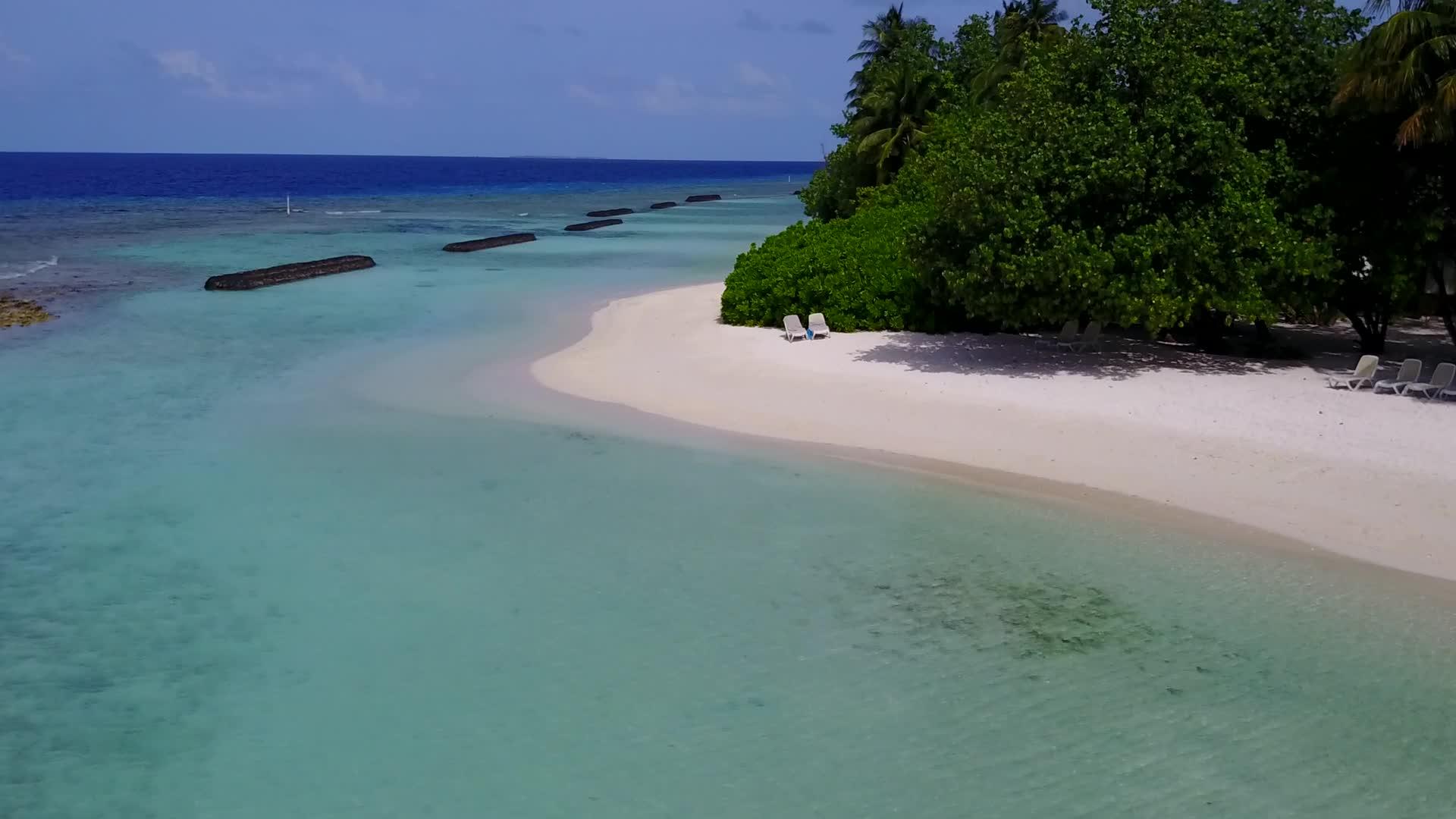 以蓝海和白色沙滩为背景的外部海湾海滩度假村有空中无人驾驶视频的预览图