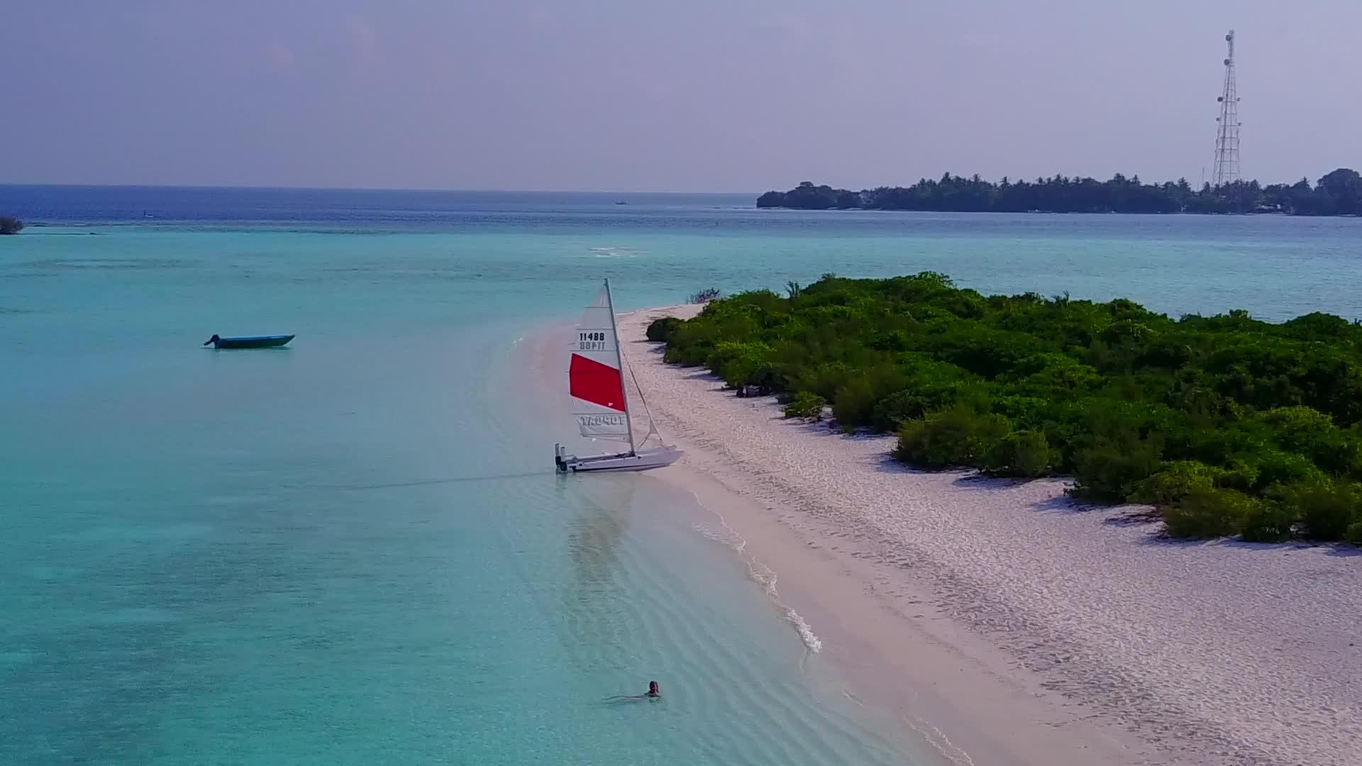 无人空中飞机以清晰的环礁湖和白色沙尘背景为特征视频的预览图