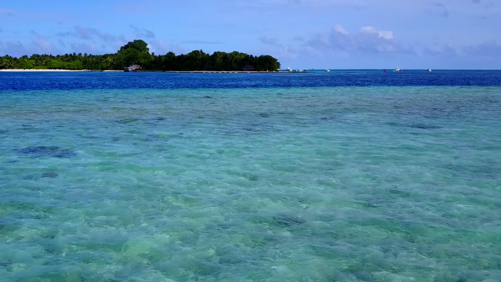 在蓝水和白沙的背景下沿着蓝水航行视频的预览图