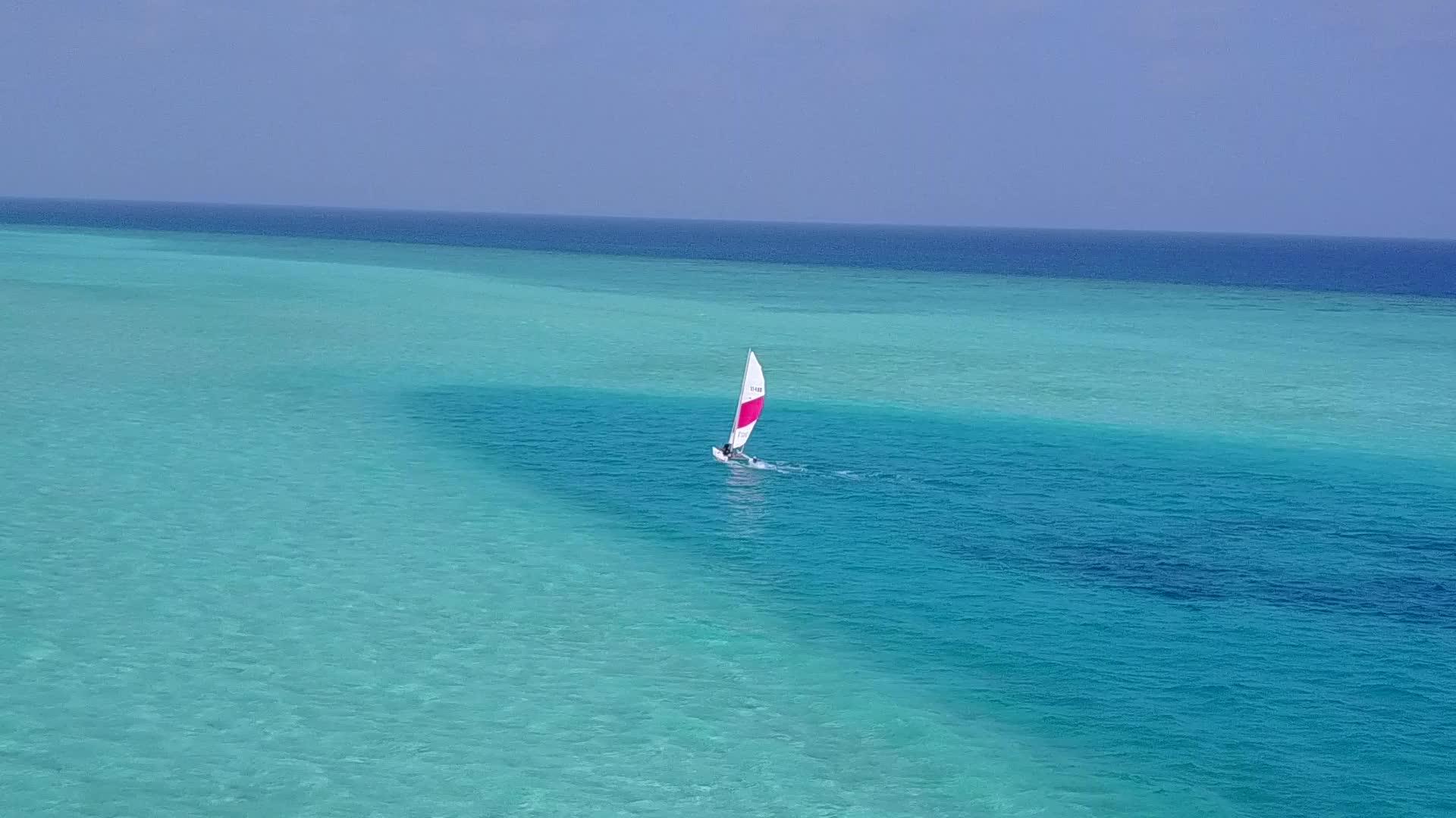 以白沙为背景的蓝色环礁湖进行海滨探险和航行视频的预览图