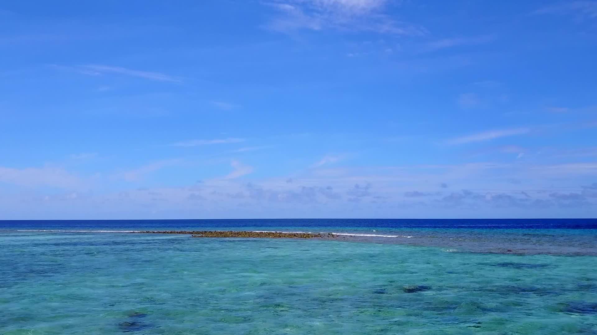 平静的海滩度假日由绿色的海洋和浅沙的背景组成在空中无人驾驶视频的预览图
