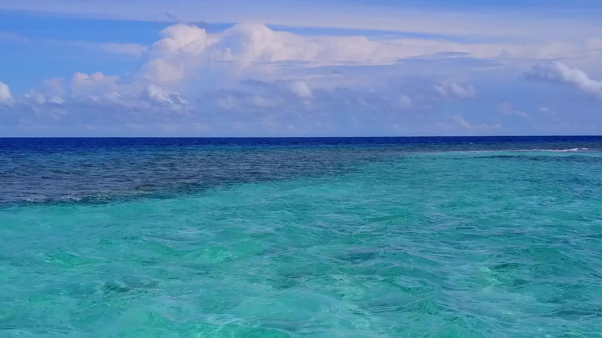 利用蓝海和干净的沙地背景从空中观察环礁湖周围罕见的野生海滩视频的预览图