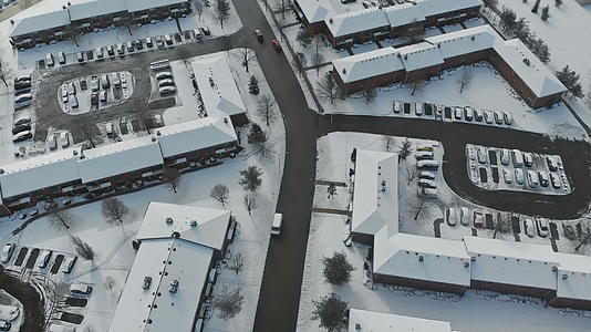 无人驾驶飞机在小城镇的房屋和街道上被雪覆盖视频的预览图