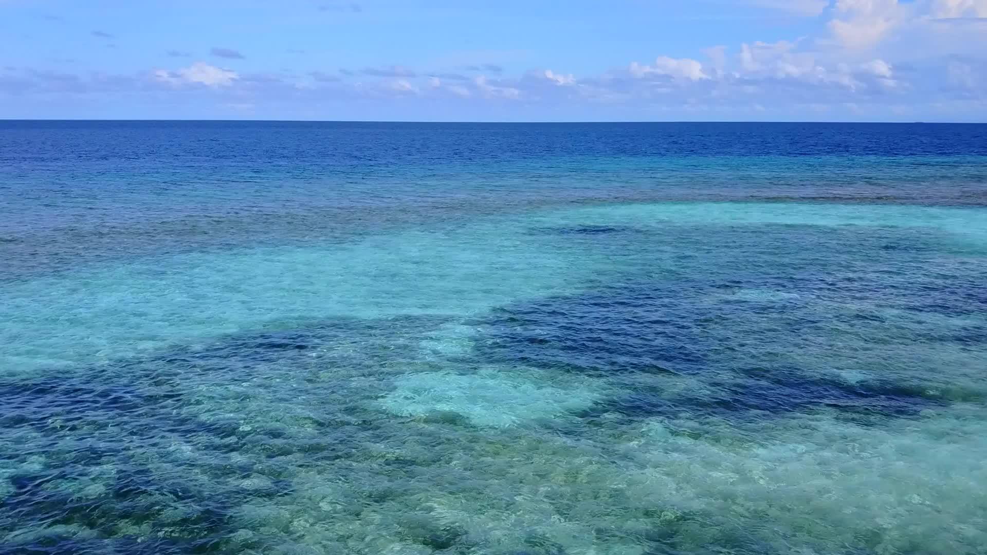 在蓝色泻湖和白色海滩的背景下完美的无人机在海岸海滩上航行视频的预览图
