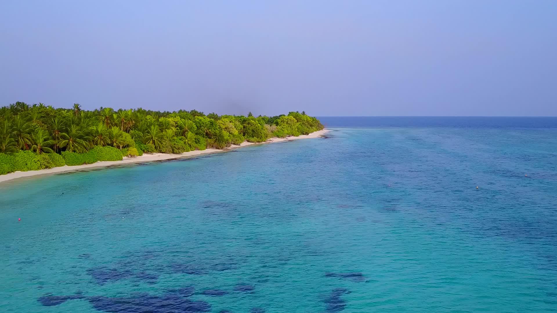 在蓝色水和白色沙底的背景下在海岸海滩上冒险的空中无人驾驶视频的预览图