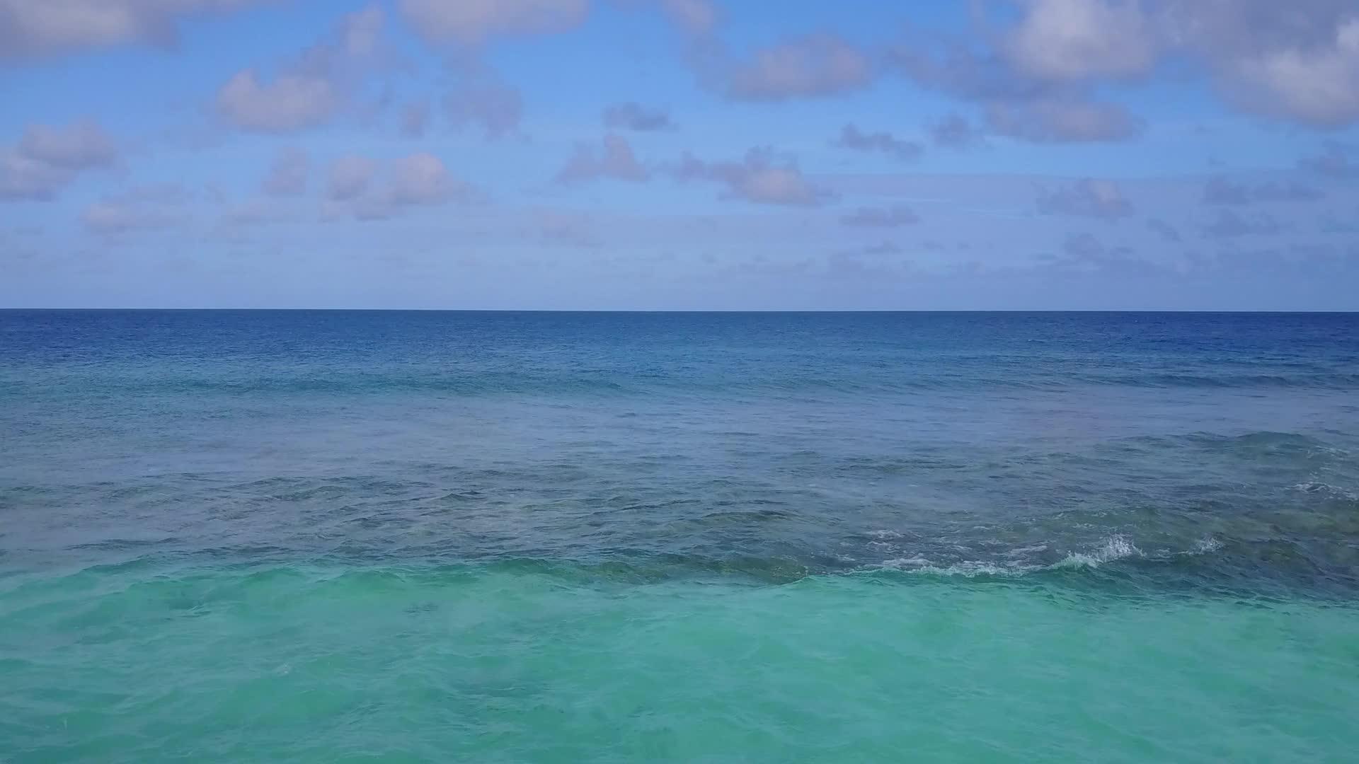 以蓝色水和白色沙底为背景的放松海滨海滩航行视频的预览图