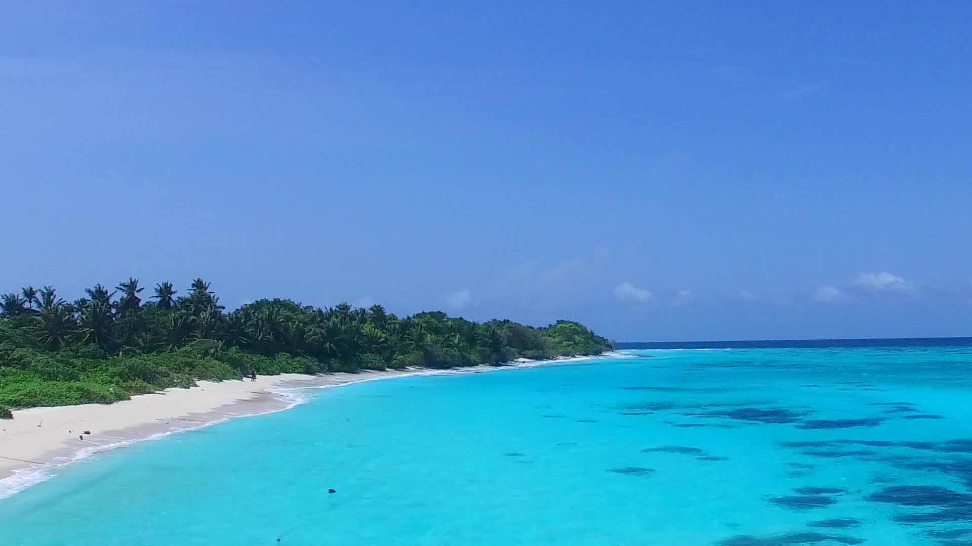 蓝色环礁湖和白色环礁湖和白色海滩为背景在海岸海滩之间休息视频的预览图