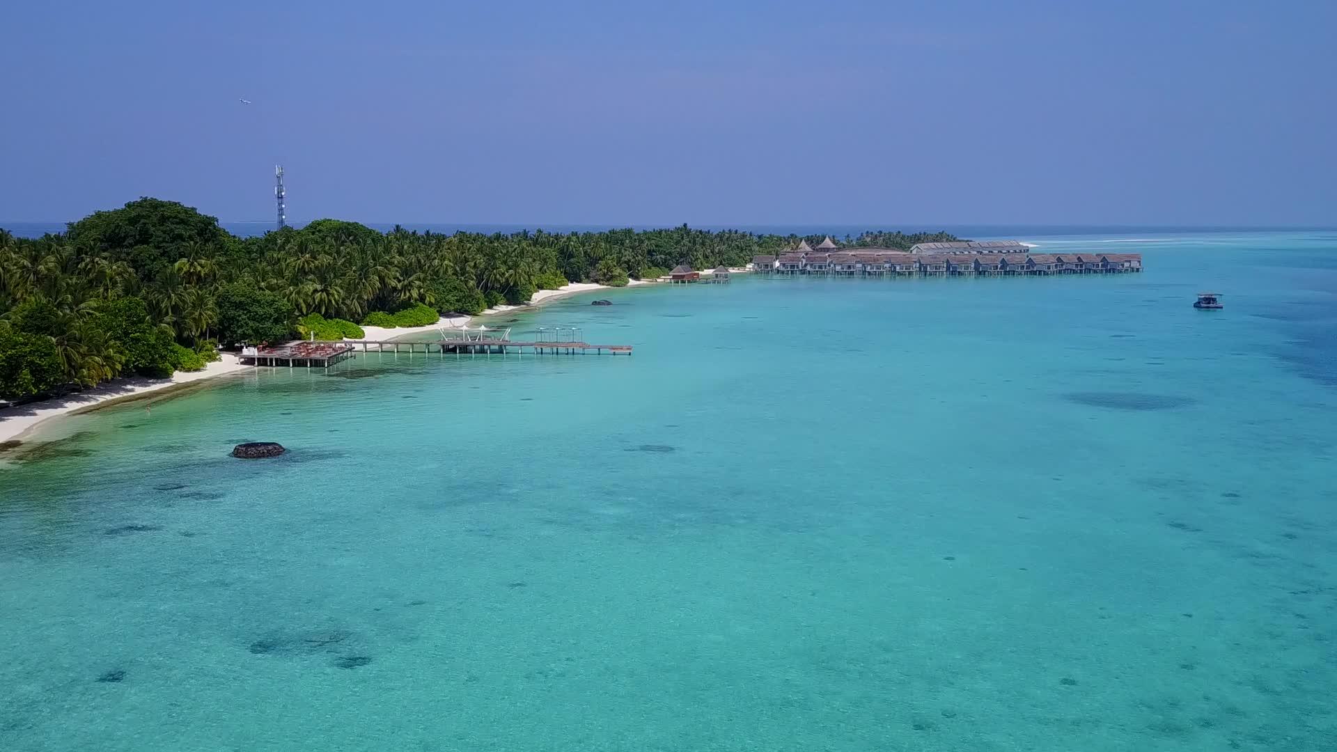 蓝沙背景的蓝色环礁湖打破了热带海岸海滩的风景视频的预览图