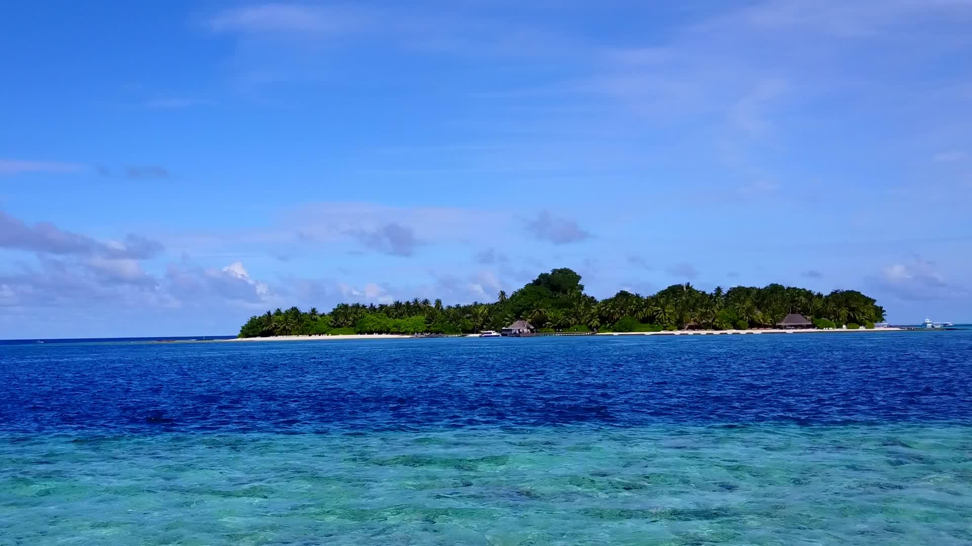 热带岛屿海滩沿着蓝绿色海洋和白色沙底蓝色海岸的空中观景视频的预览图