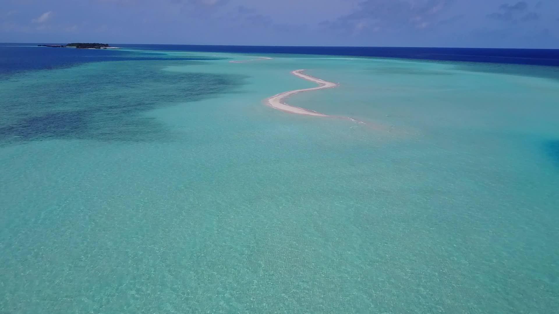 蓝色环礁湖以白色沙子为背景作为海岸航次在空中进行海景航行视频的预览图