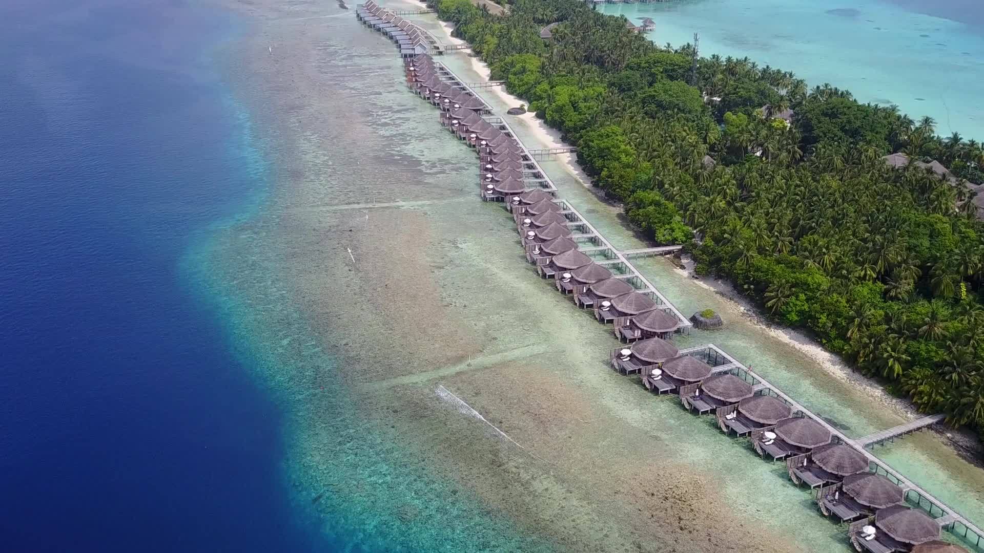 以蓝色环礁湖和白色沙底为背景放松空中旅游海滩时间视频的预览图