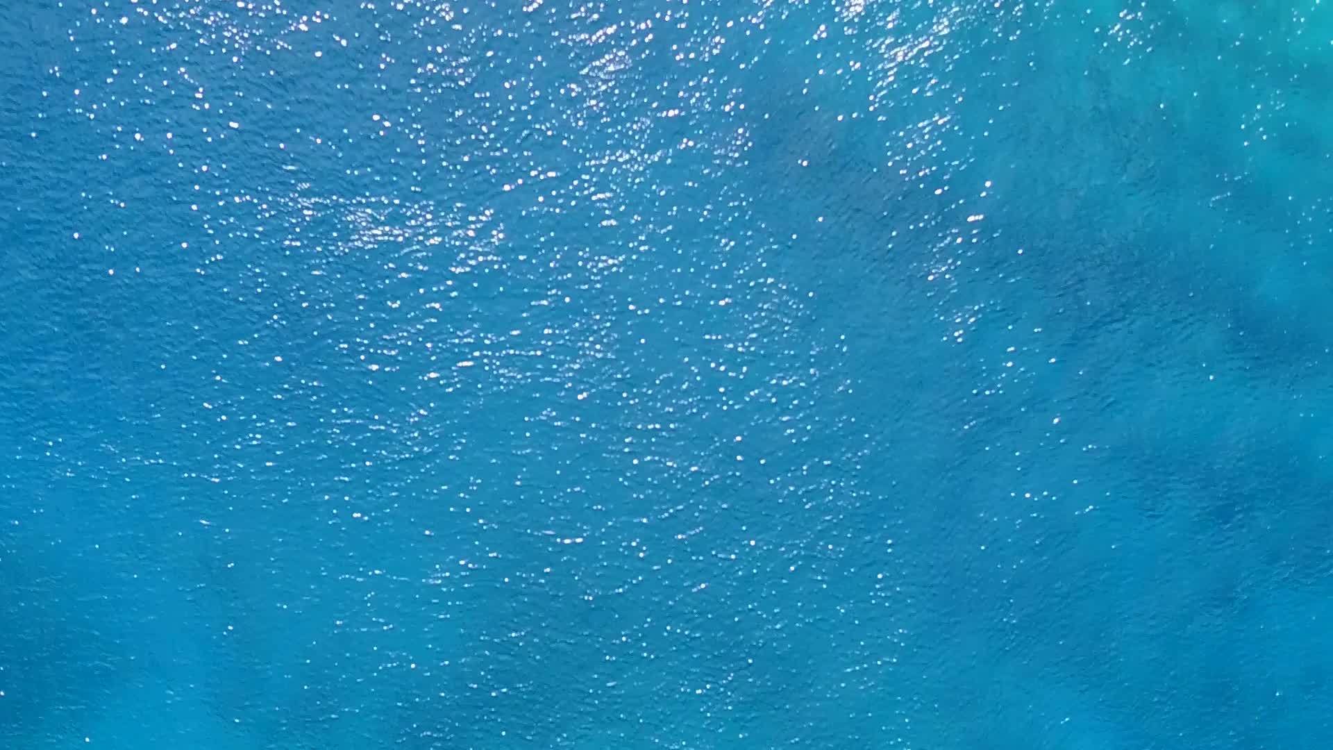 空中无人驾驶以浅环礁湖和白色沙滩的背景打破海洋环礁海滩视频的预览图