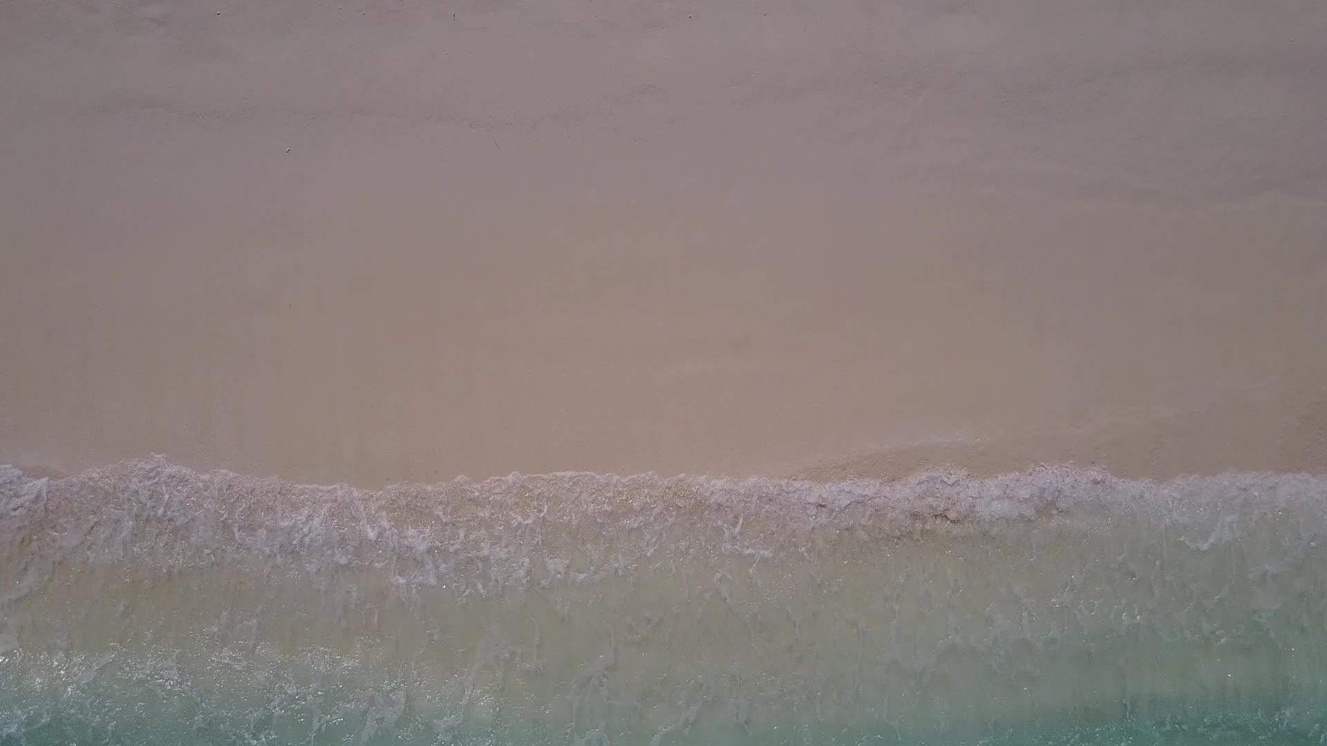 完美的天空打破了蓝绿色的大海和干净的海滩背景视频的预览图