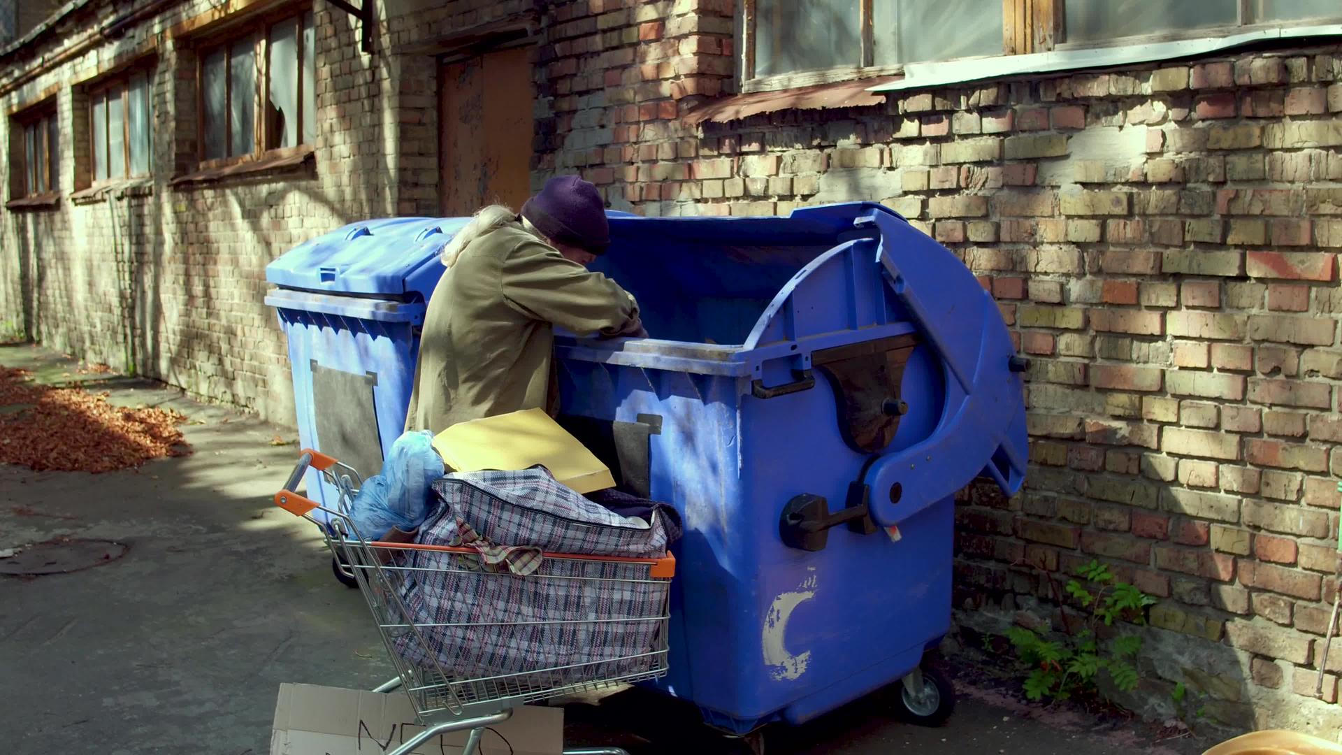 流浪汉在垃圾中寻找食物和空瓶子这部电影里有无家可归的人视频的预览图