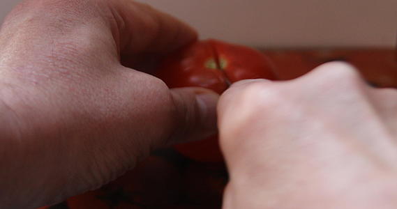 将成熟的番茄切在切割板上视频的预览图