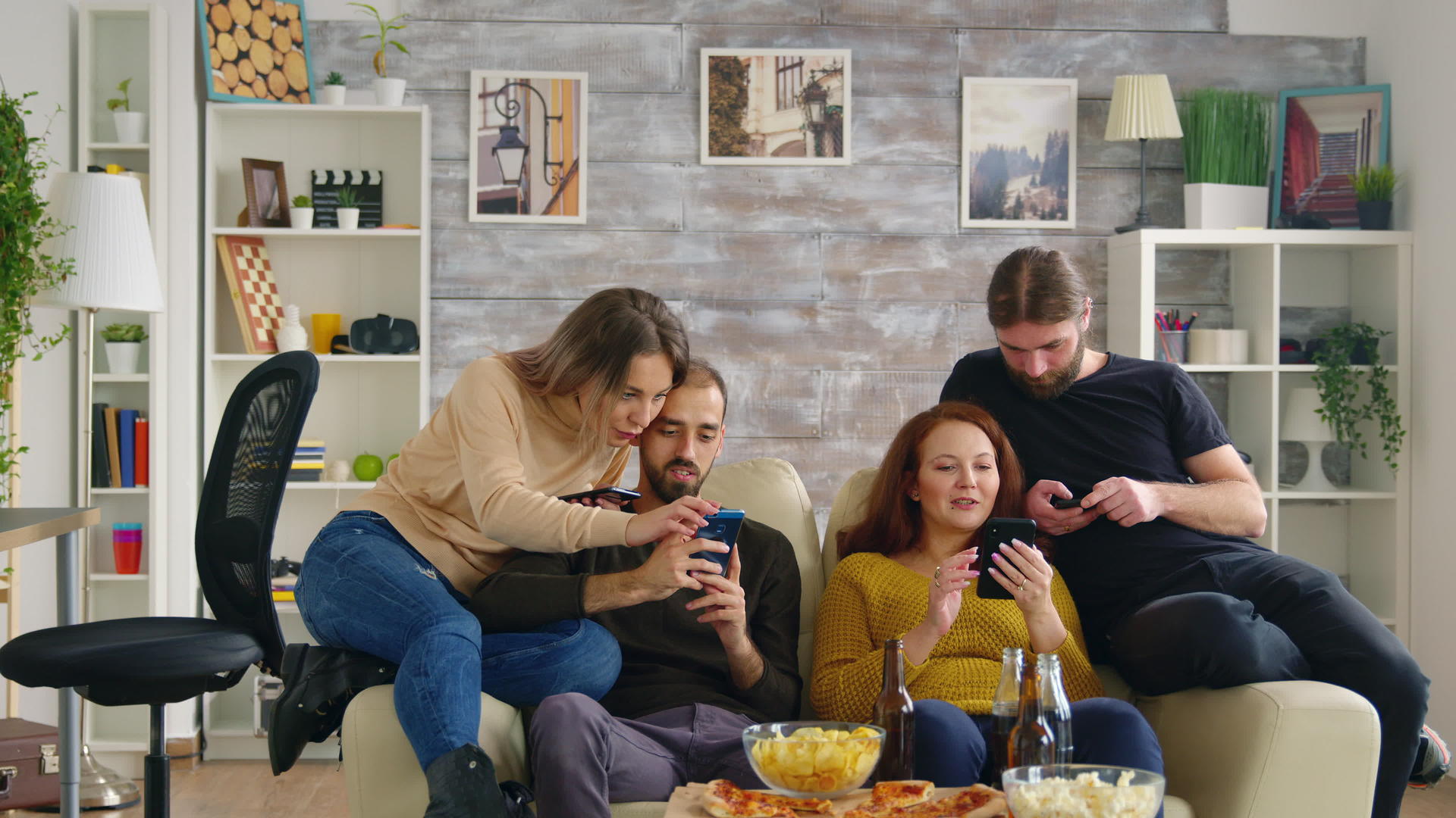 一群朋友用智能手机坐在沙发上视频的预览图
