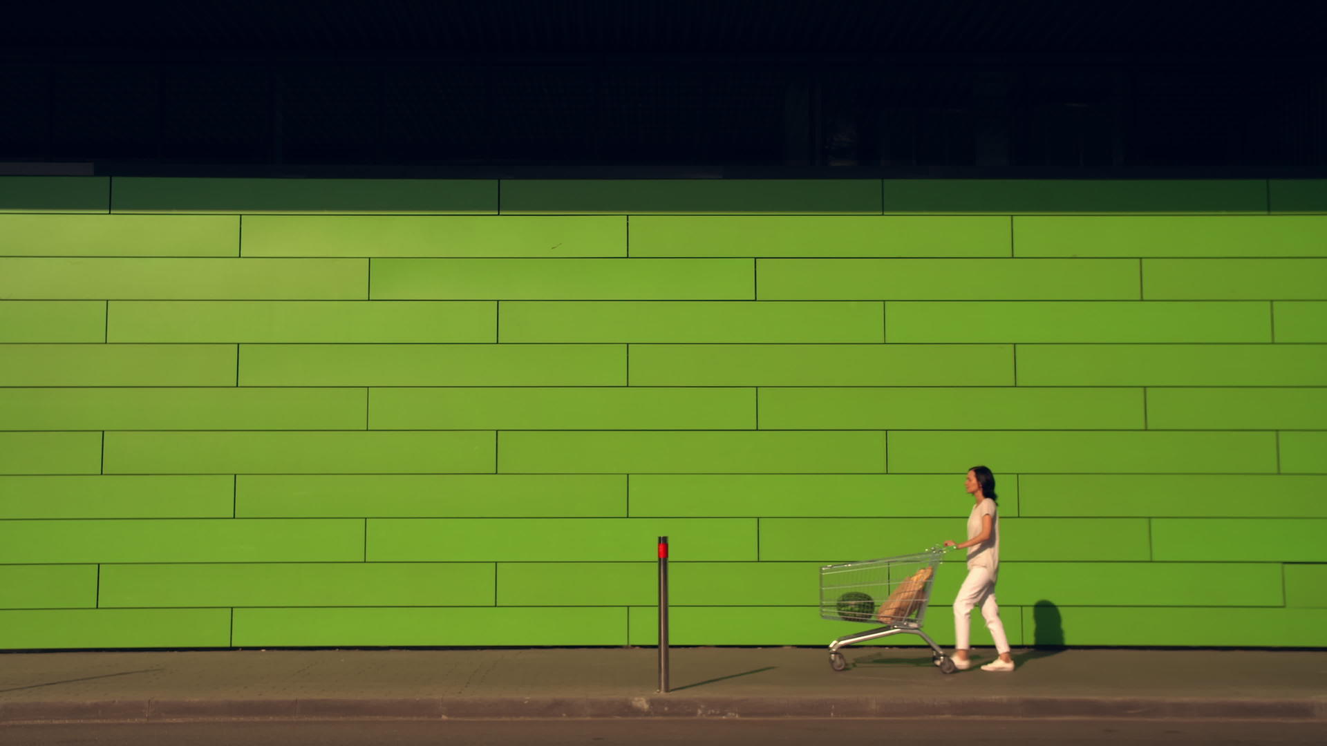 女人沿着绿墙走视频的预览图