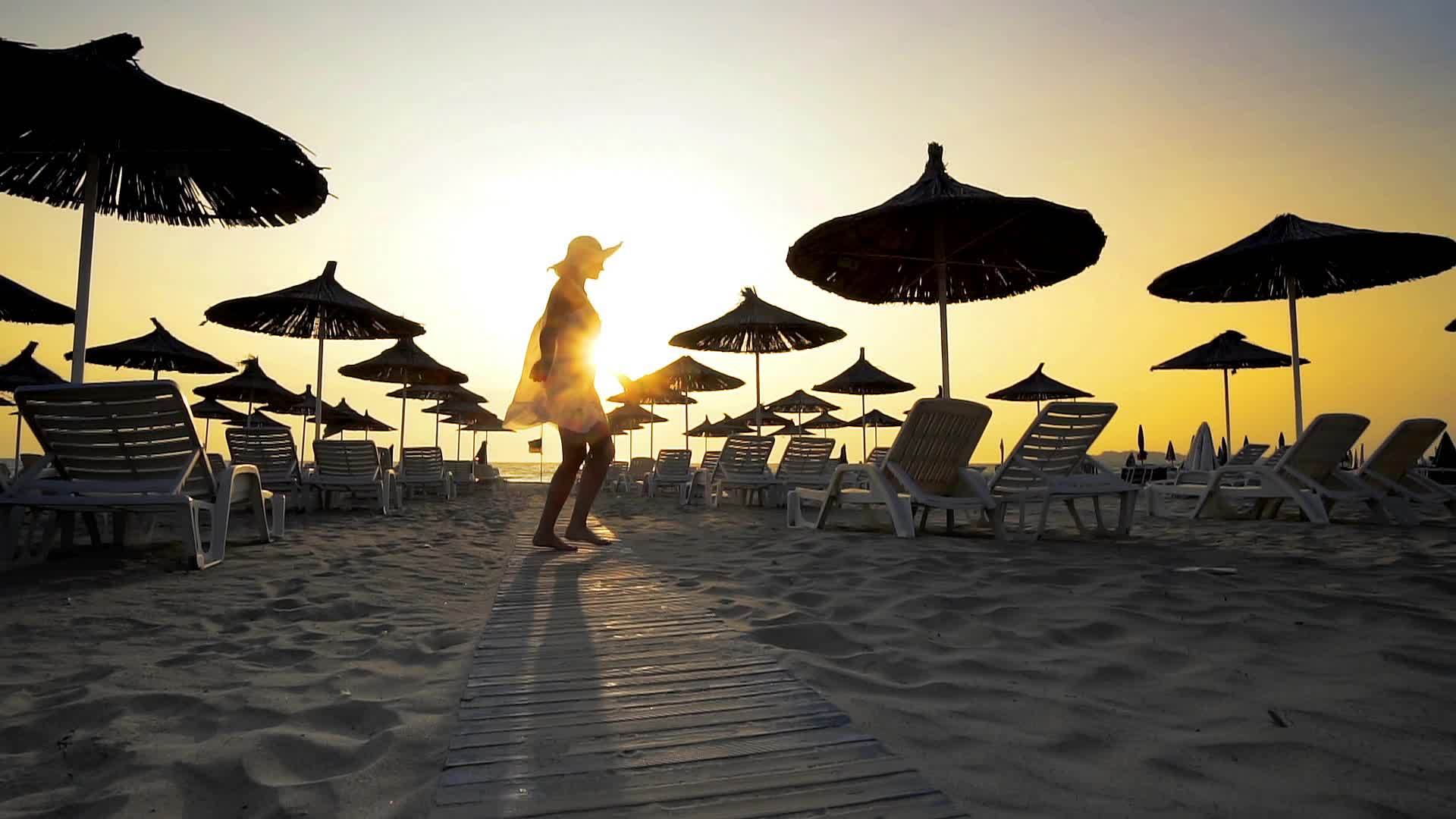 穿着草伞和床的空旷美丽的海滩和日落电影拍摄的场景视频的预览图