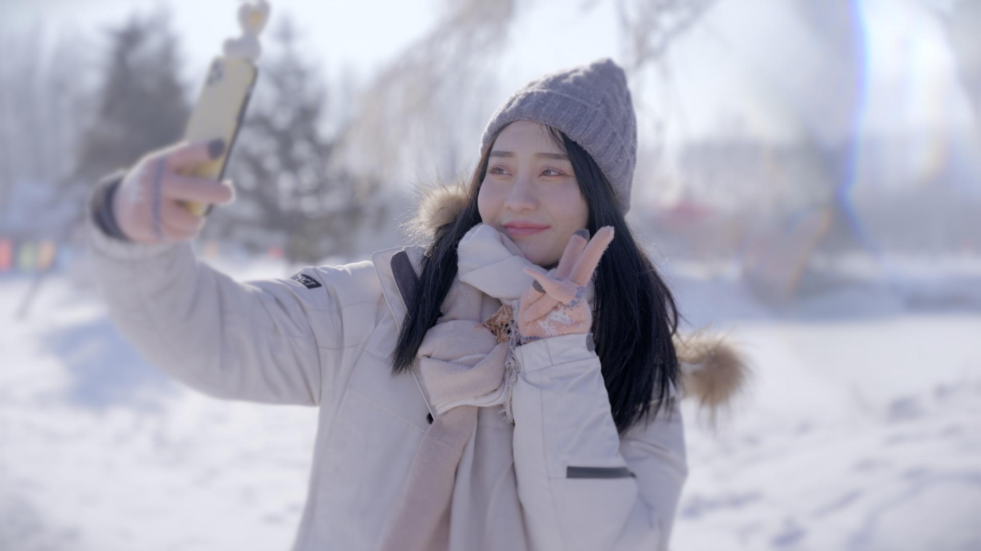 4k冬天户外景区雪景女孩手机自拍视频的预览图