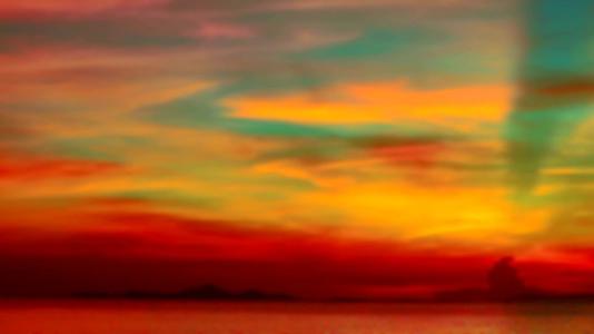 在红蓝的天空下明亮的太阳落在黄橙色的云下视频的预览图