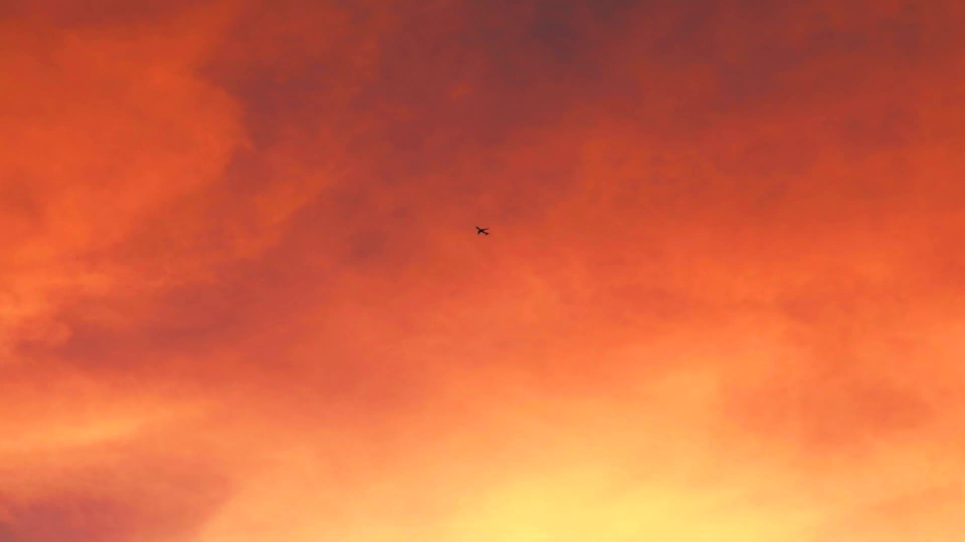 飞机在天空中以日落云的橙红色飞行视频的预览图