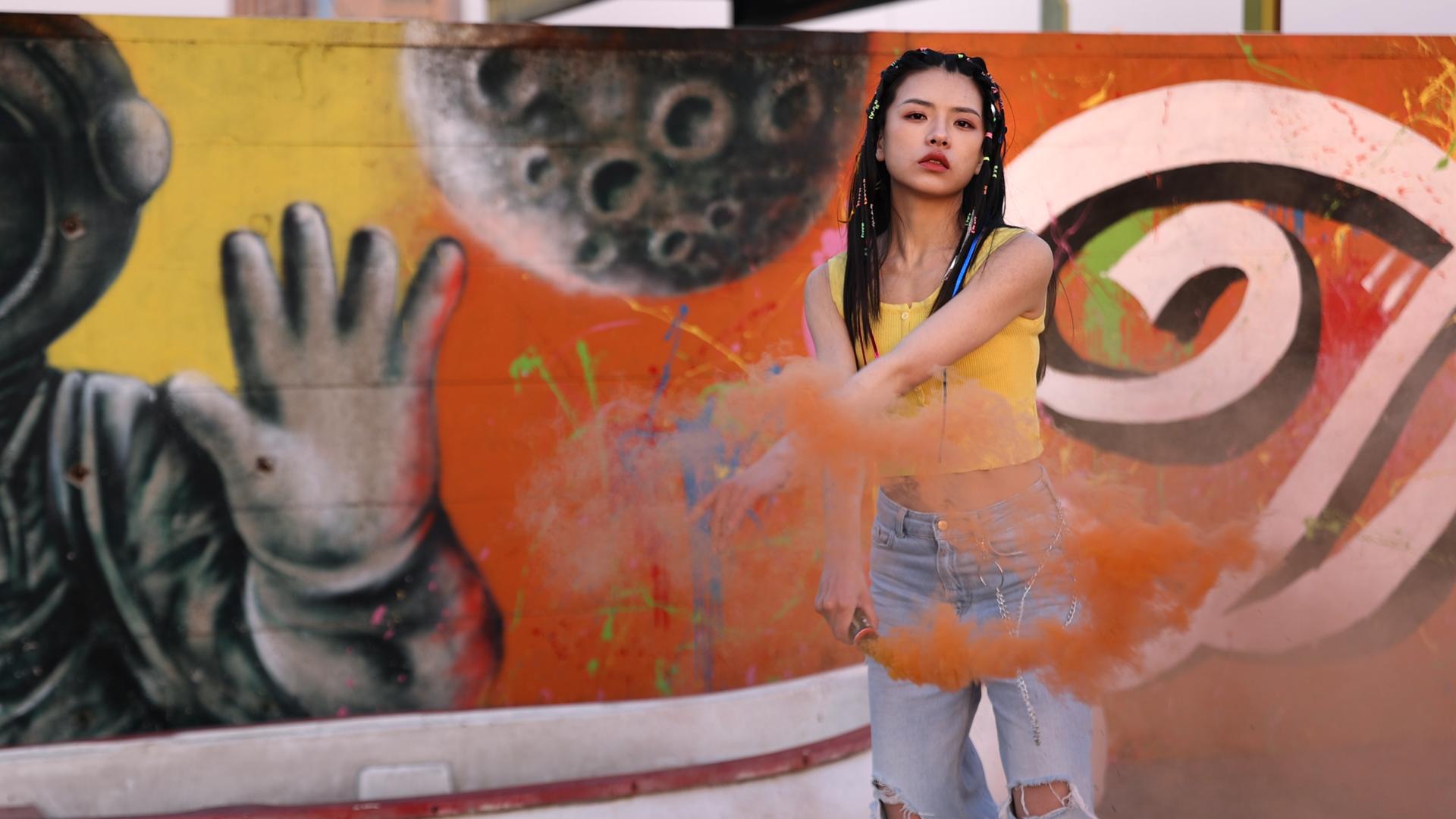 4K潮流嘻哈女孩涂鸦墙下挥动烟雾棒劲舞视频的预览图