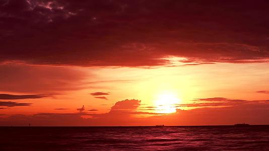 红色的太阳橙色的天空和深红的云在海上飘扬视频的预览图