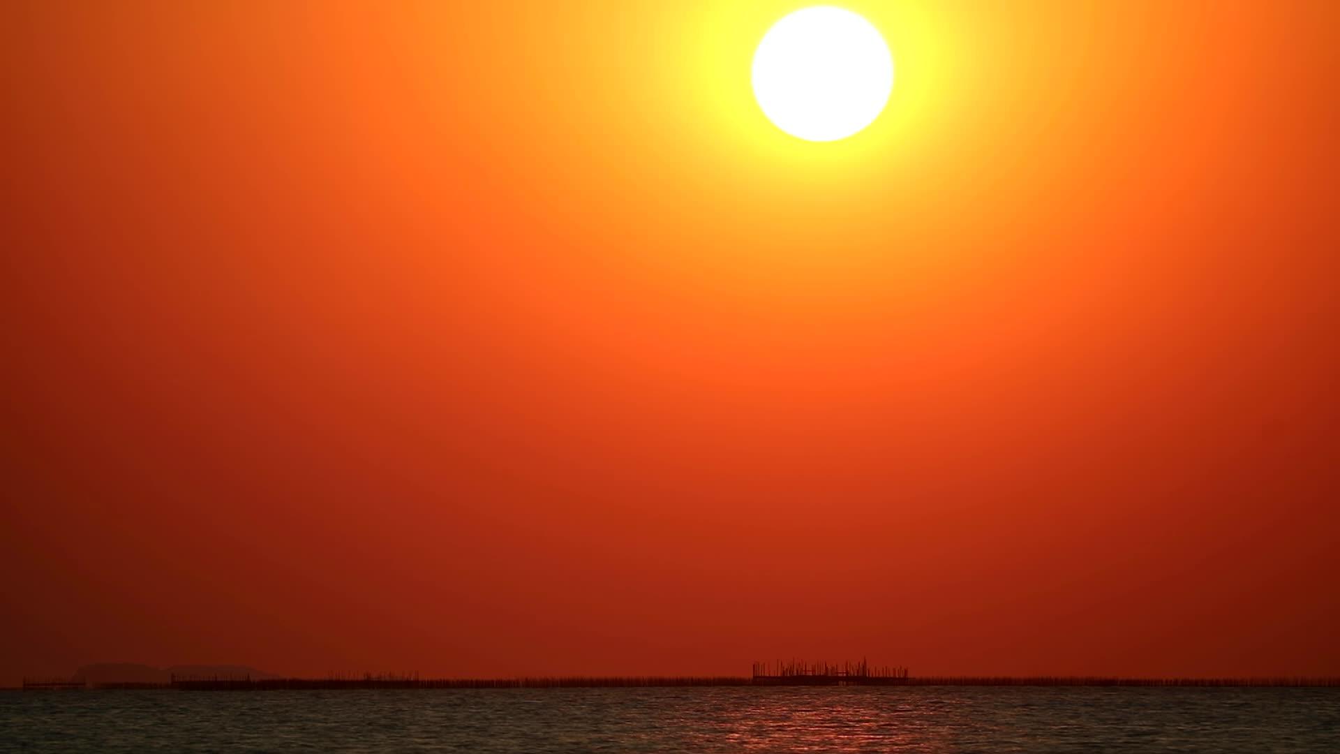 阳光灿烂日落白橙色的云在海中消失视频的预览图