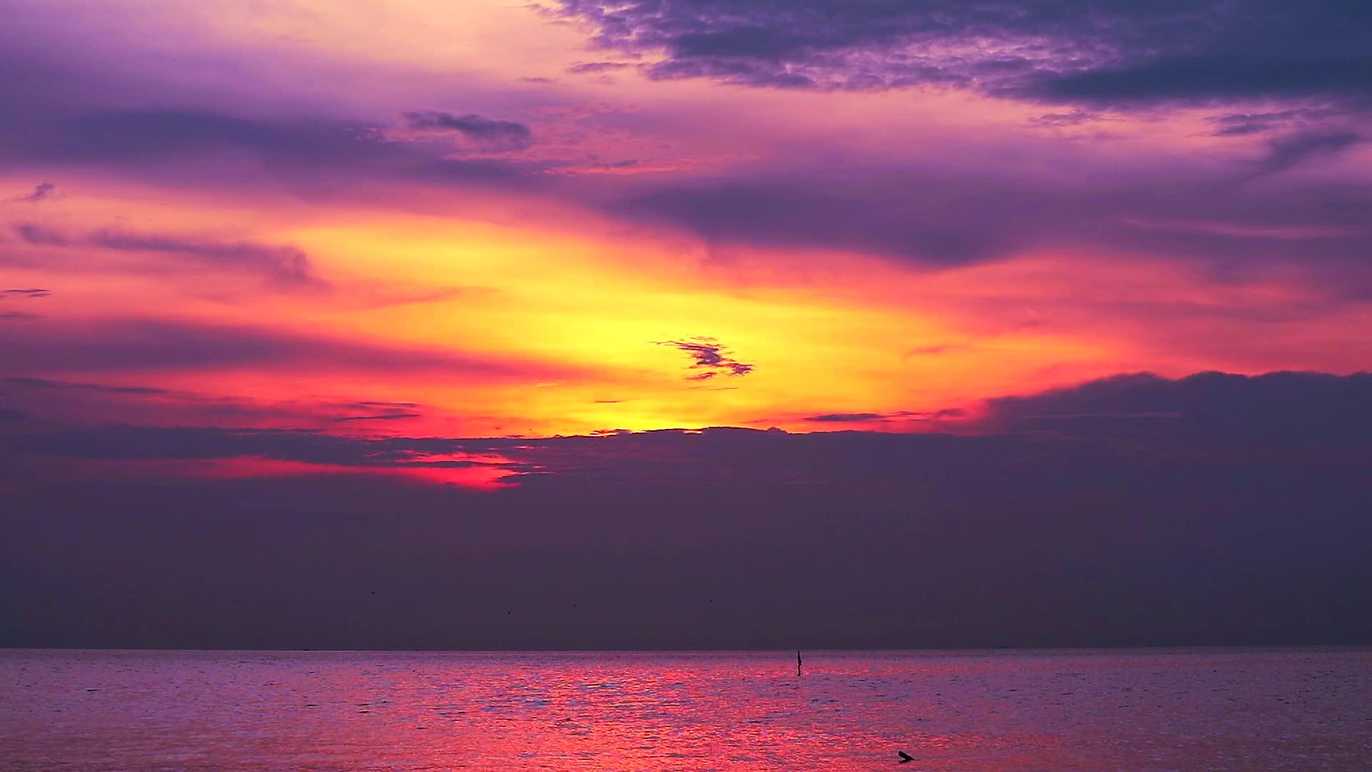 红云落在海面和橙色天空的背景下视频的预览图