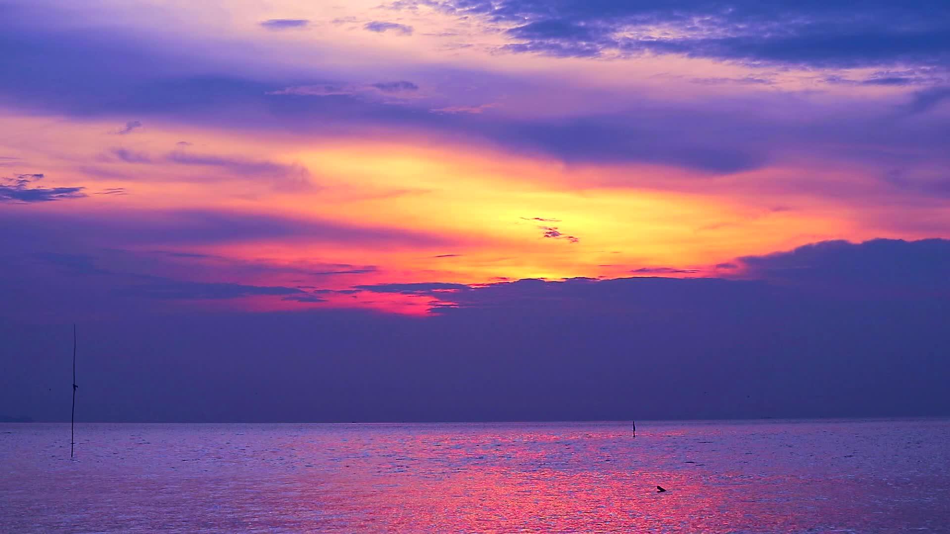 海面和橙色天空背景的红云落在夕阳紫色1视频的预览图