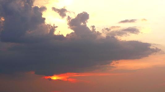 在海面、水面和天空的乌云下有红色的太阳视频的预览图