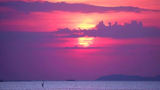 海面和海面小浪上的日落和紫云移动渔船的航道1视频的预览图