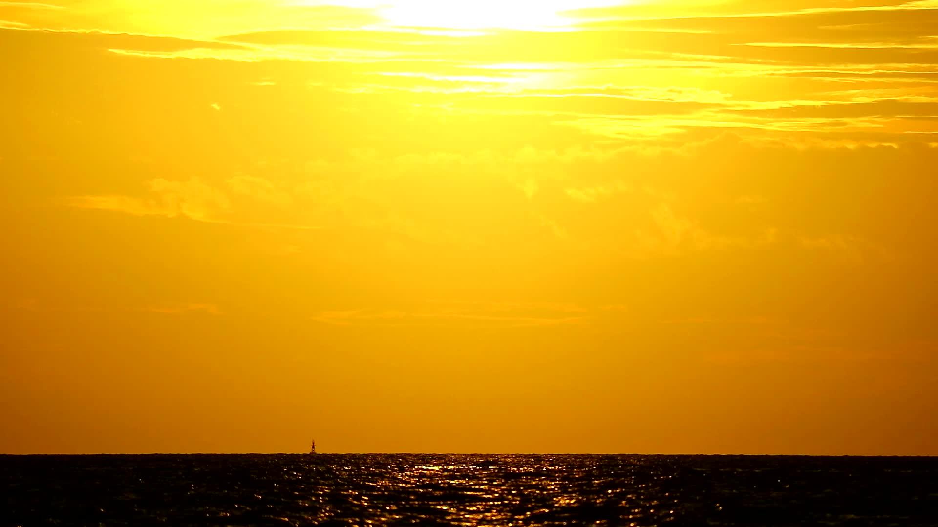 黄色的太阳落在海里太阳落山后金色的云和天空视频的预览图