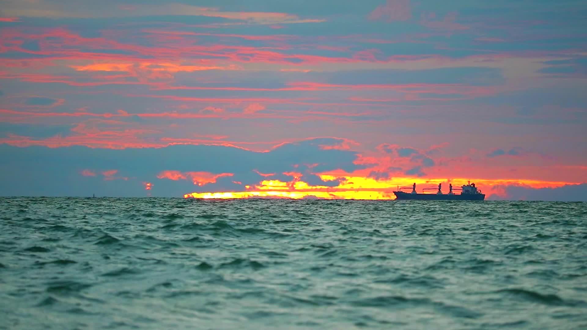 停泊在海上的货船和日落天空的云停靠视频的预览图