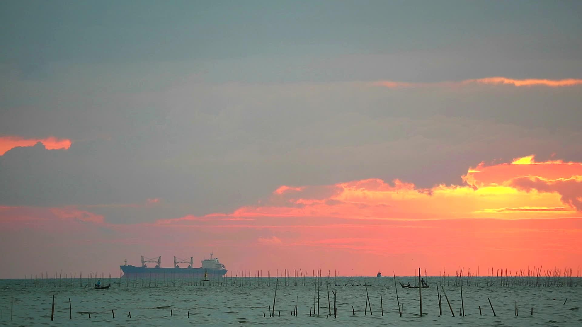 停泊在海上的货船和天空中的日落云视频的预览图